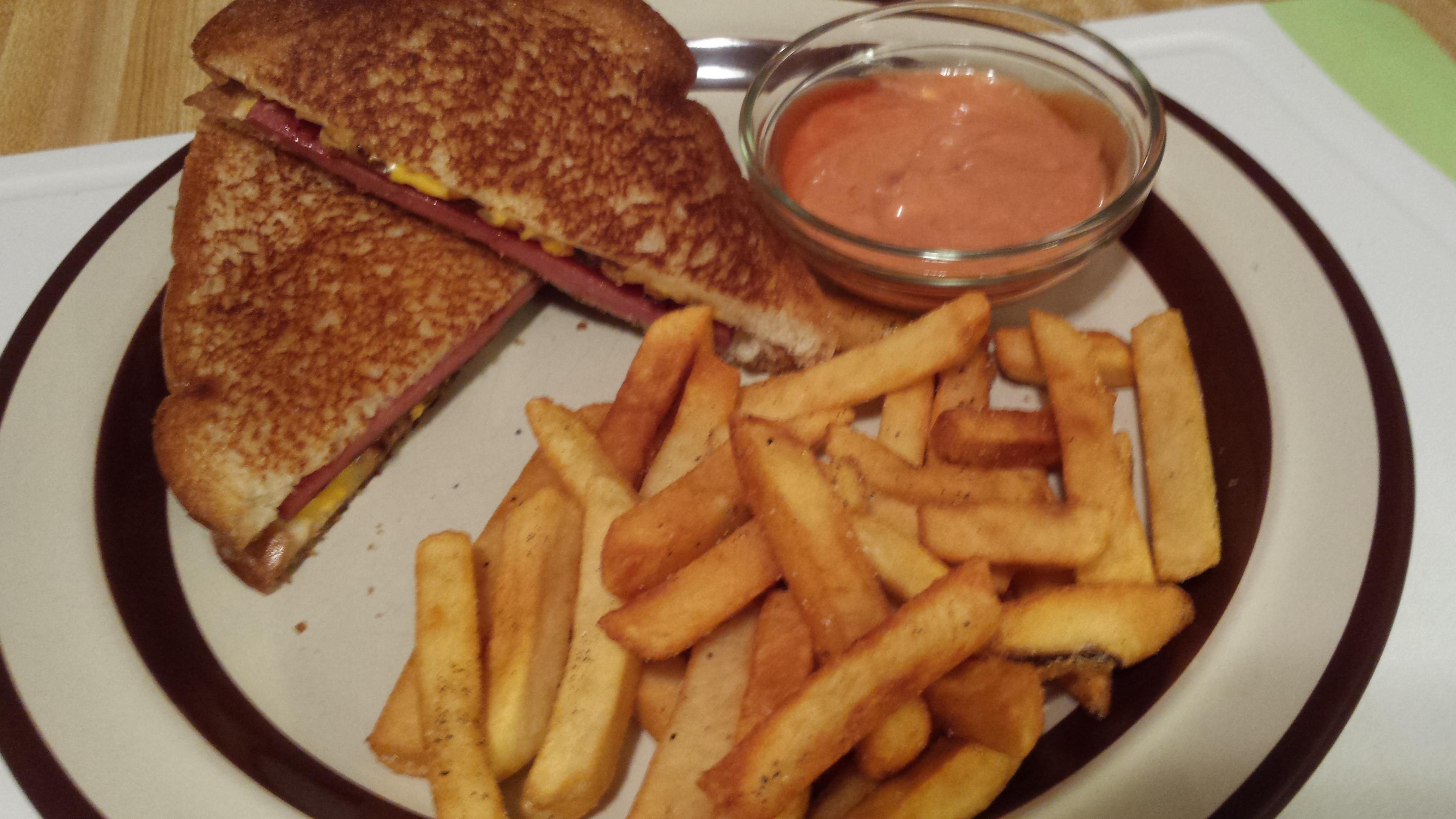 Bologna and cheese melt with caramelized onions, fries and fancy sauce