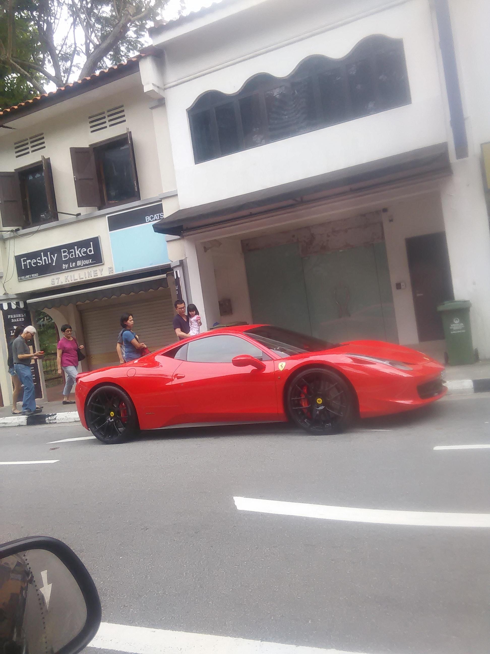 Red [Ferrari 458] parked alongside a road in Singapore (Old picture