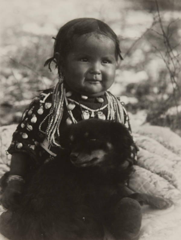 A young girl of the Crow tribe with her pet. Montana. 1910. r