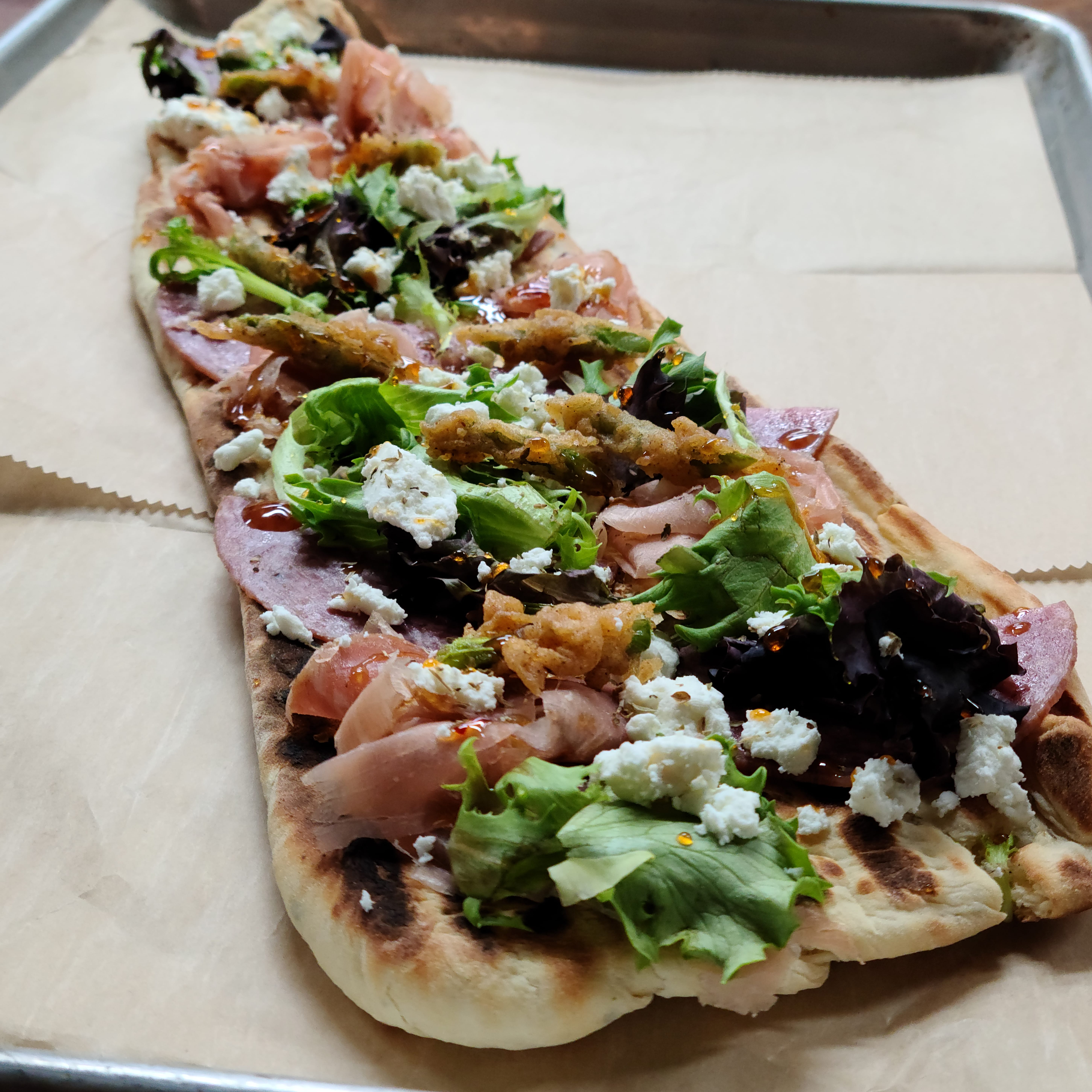My house made herb truffle flatbread with local goat cheese, genoa