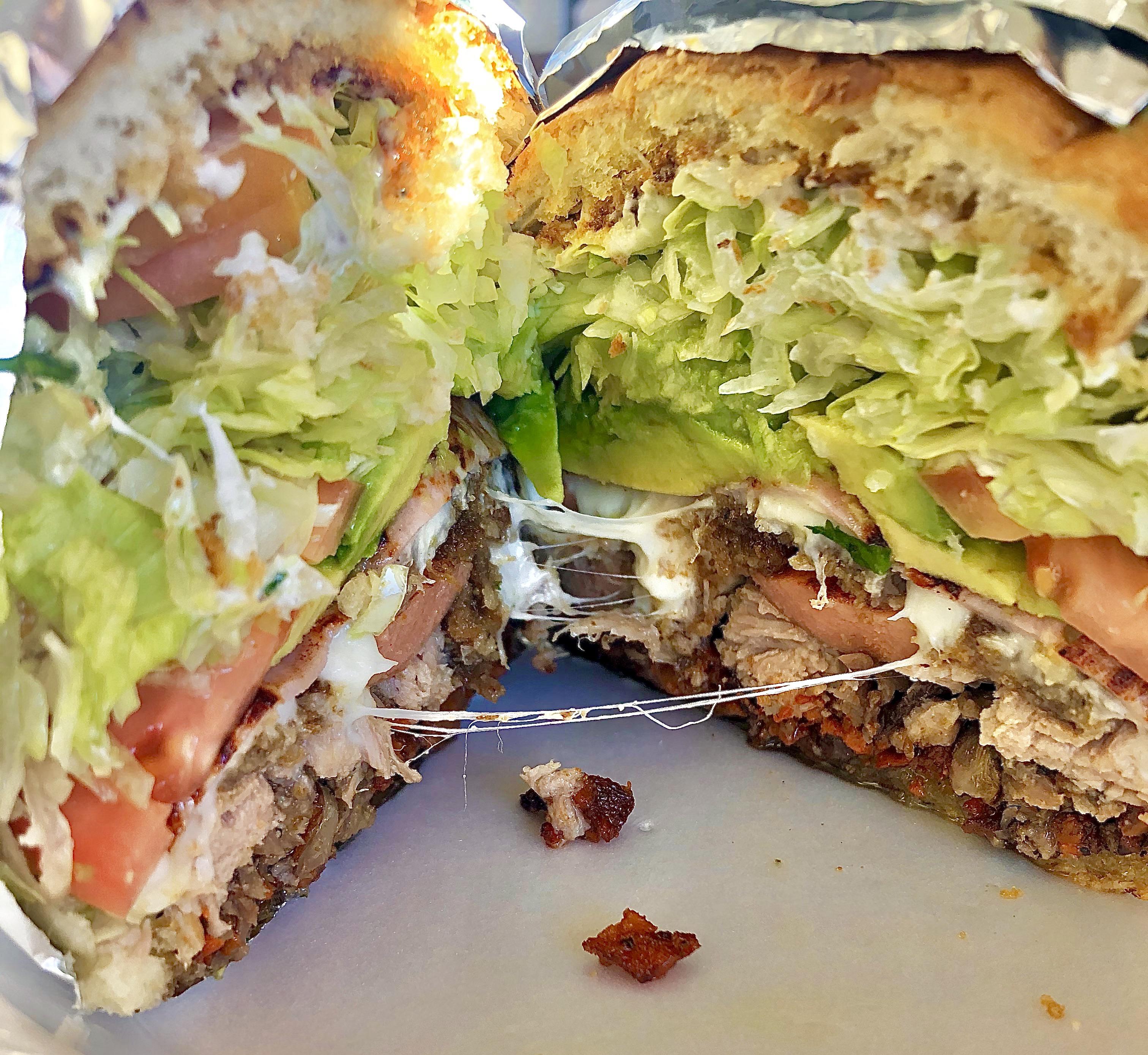 A beastly torta Cubana with crumbled chorizo, carne asada, pork