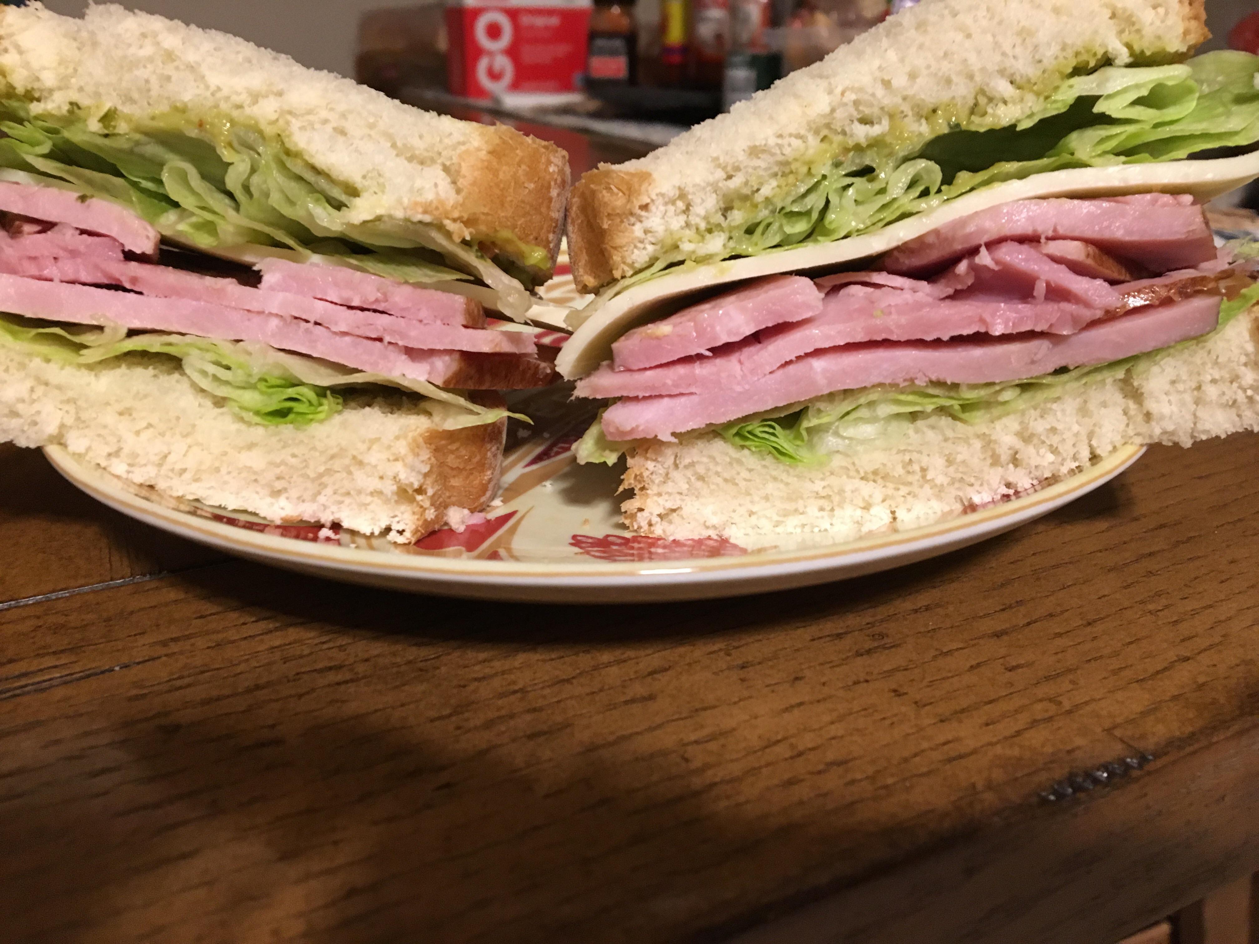 Ham, lettuce, spicy guacamole, and Asiago cheese on artisan white bread