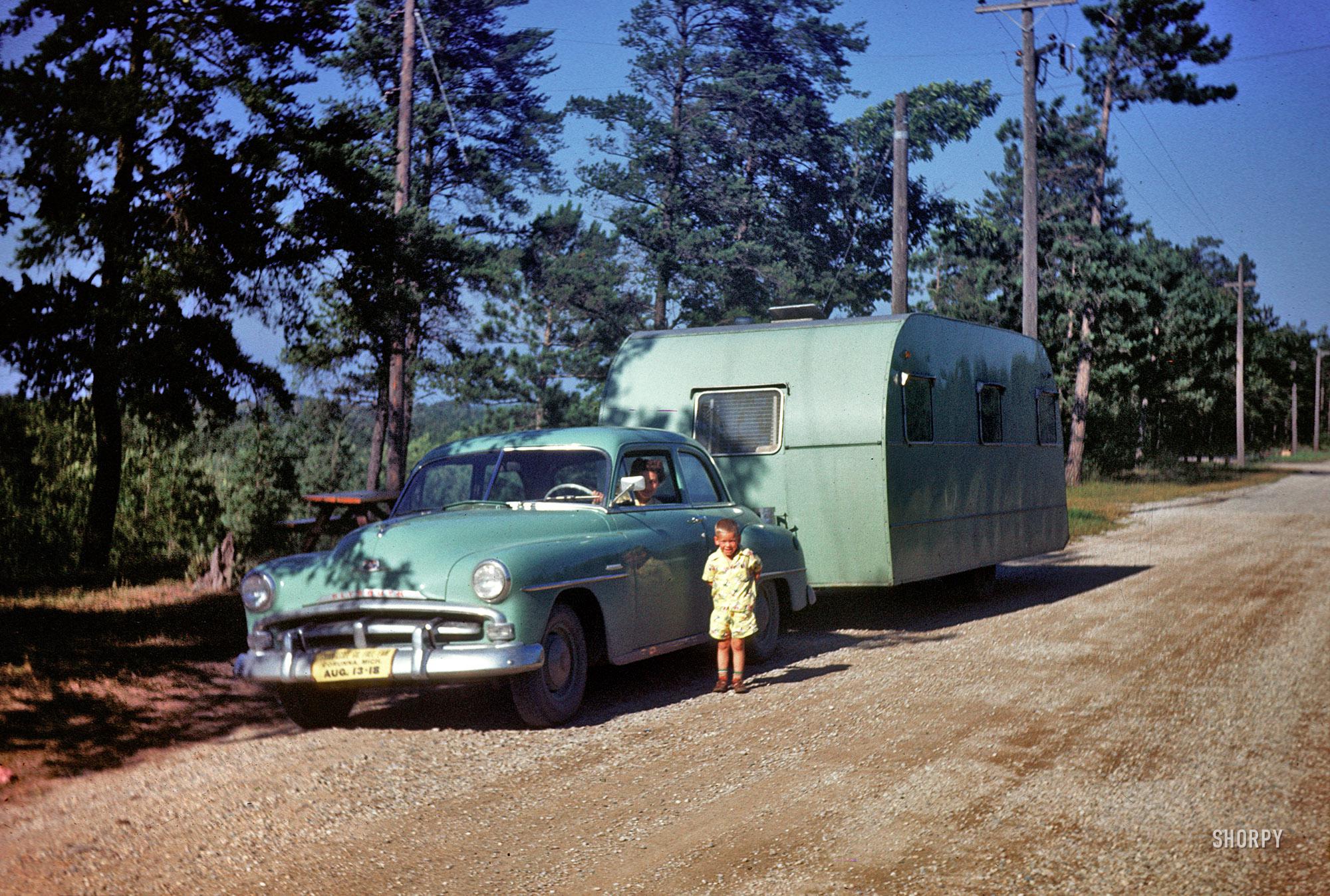 Burt Lake, 1951.Our young man with color coordinated Plymouth and travel trailer, and Mama at