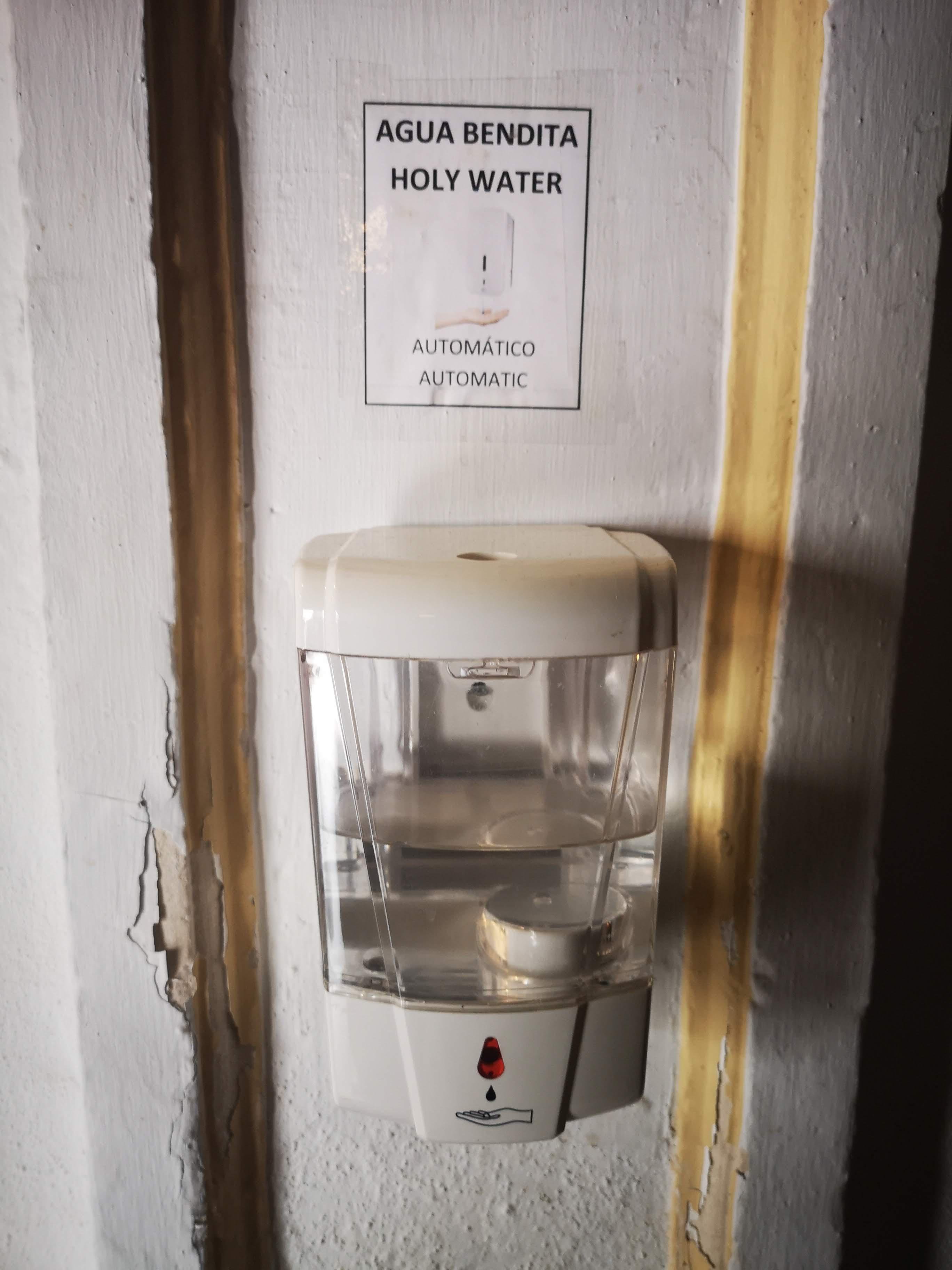 automated holy water dispenser seen in a church in Spain r