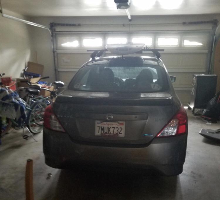Stolen Car! Silver/Bronzish Nissan Versa with a roof rack, stickers on both bottom corners of