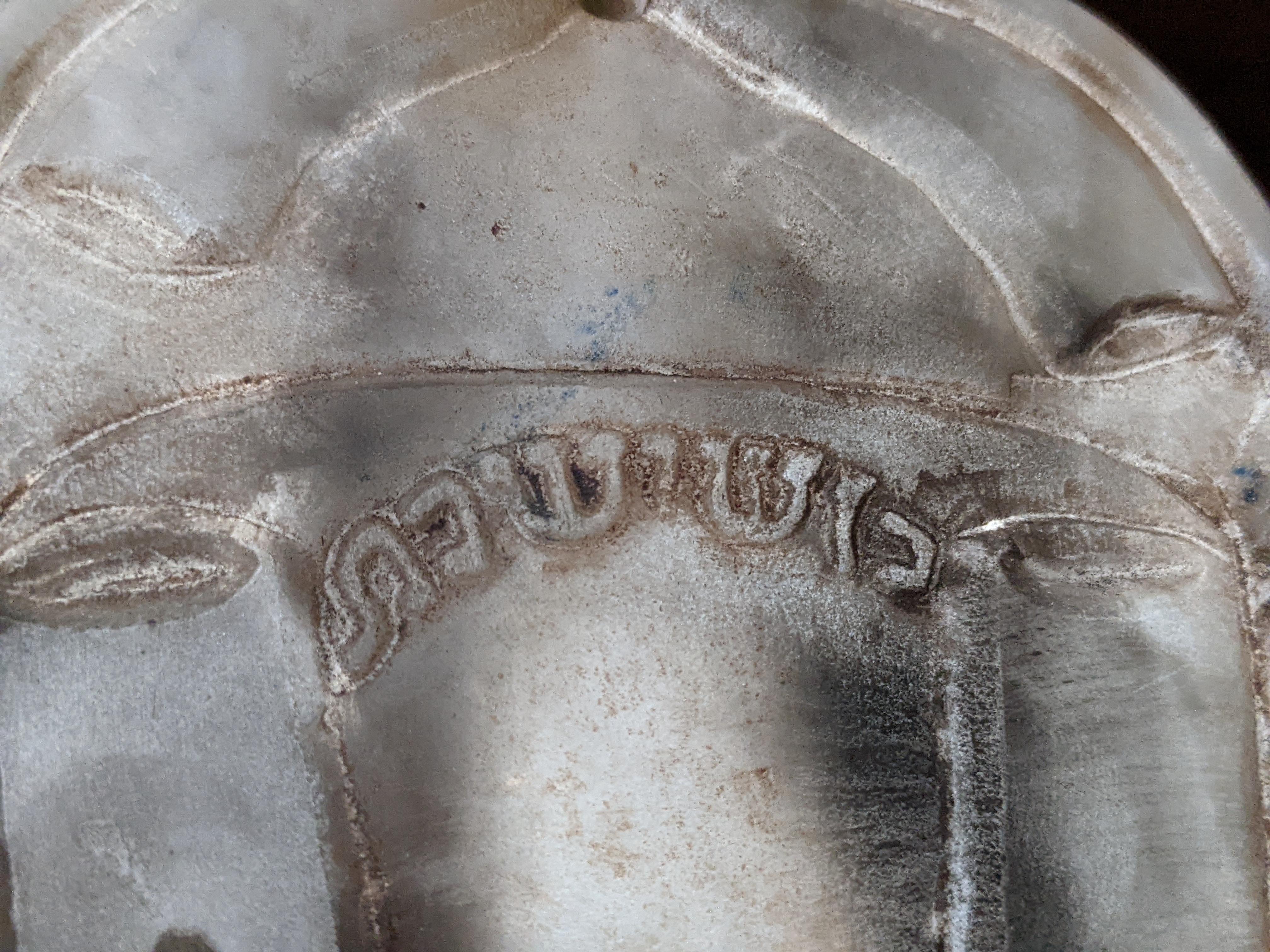 What does this say? Carved on what I think is a representation of a