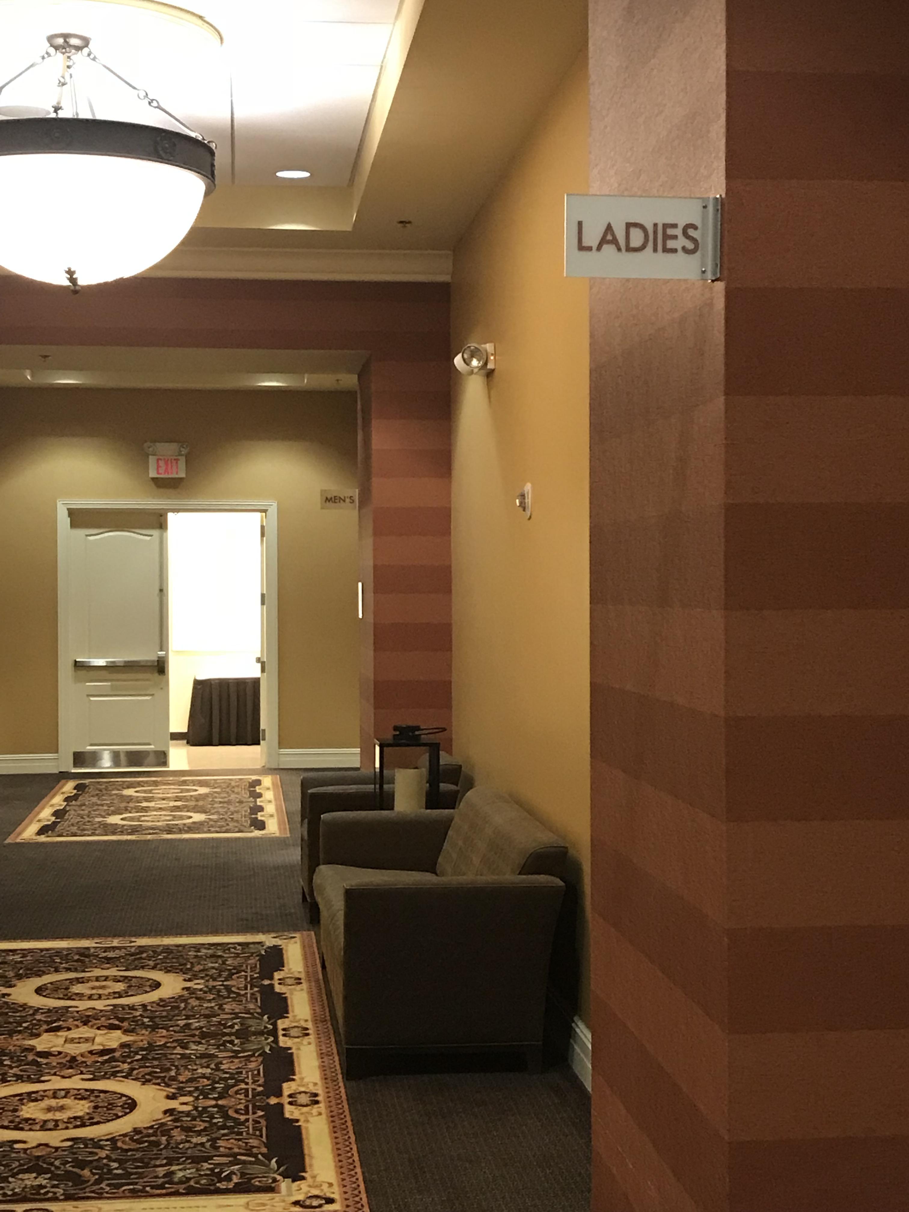 The men’s bathroom sign is possessive, but the women’s bathroom sign is