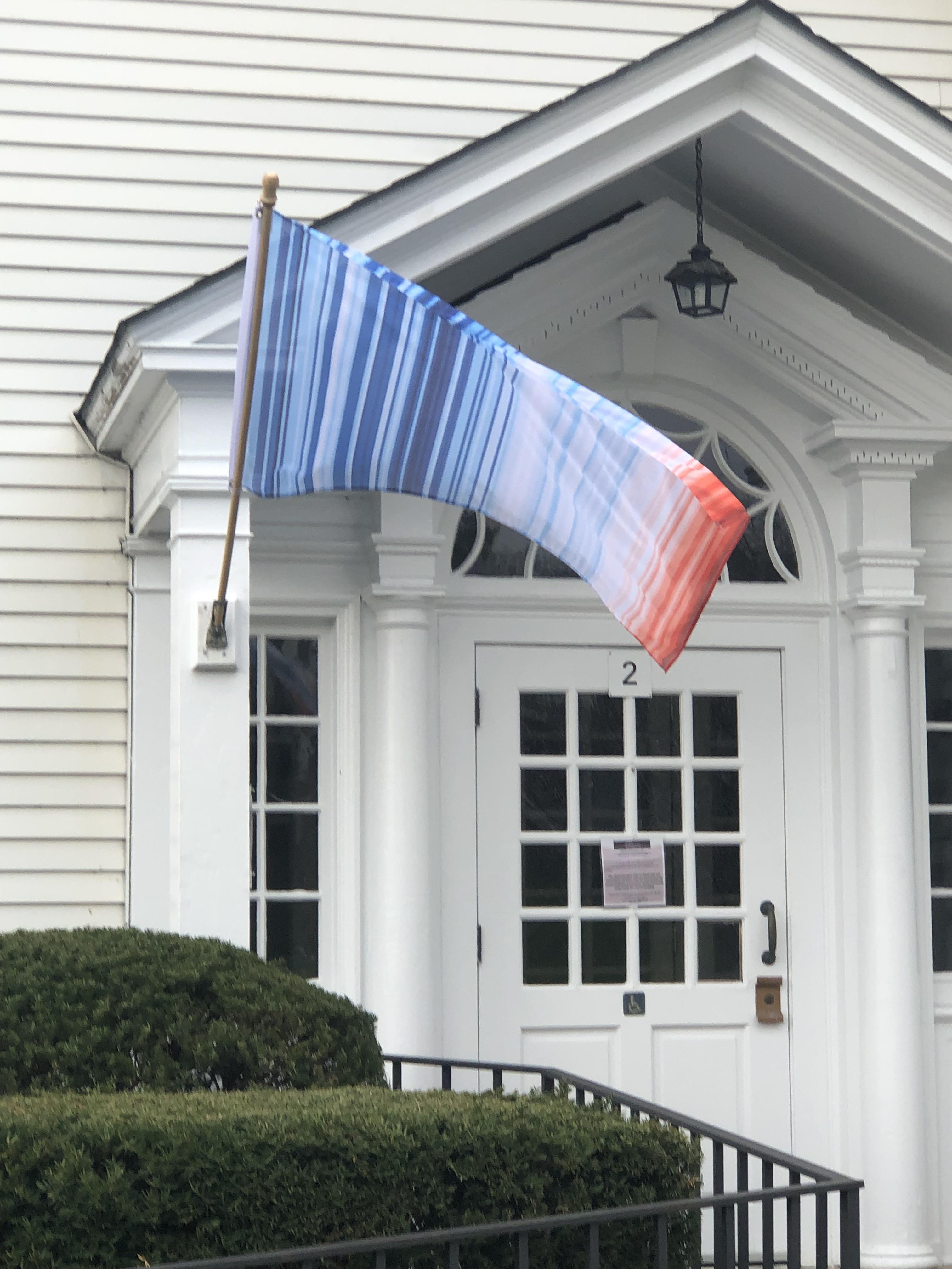A flag displaying a warming stripes graphic, showing annual global