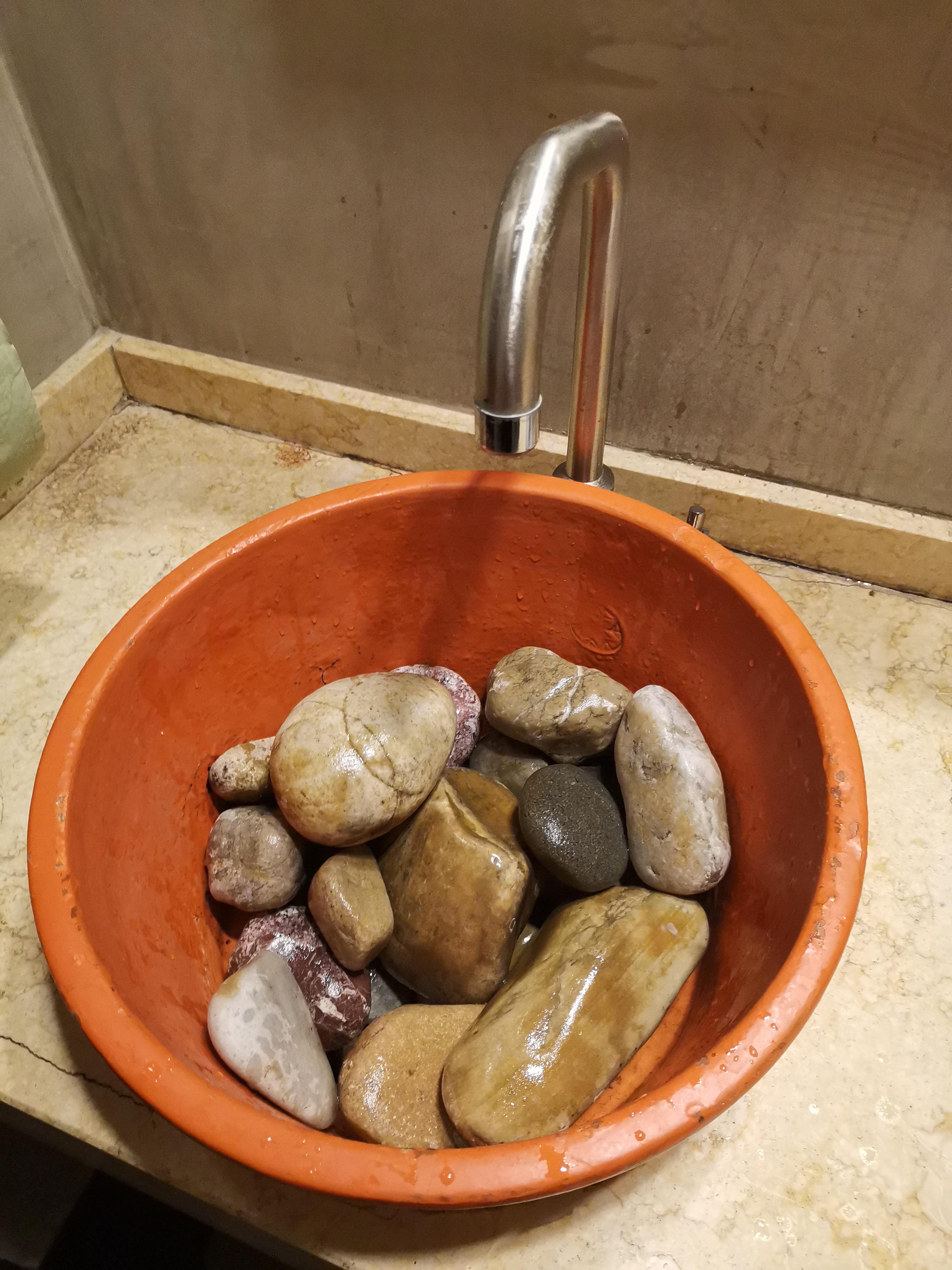 This sink in a restroom of a restaurant with rocks inside it : r