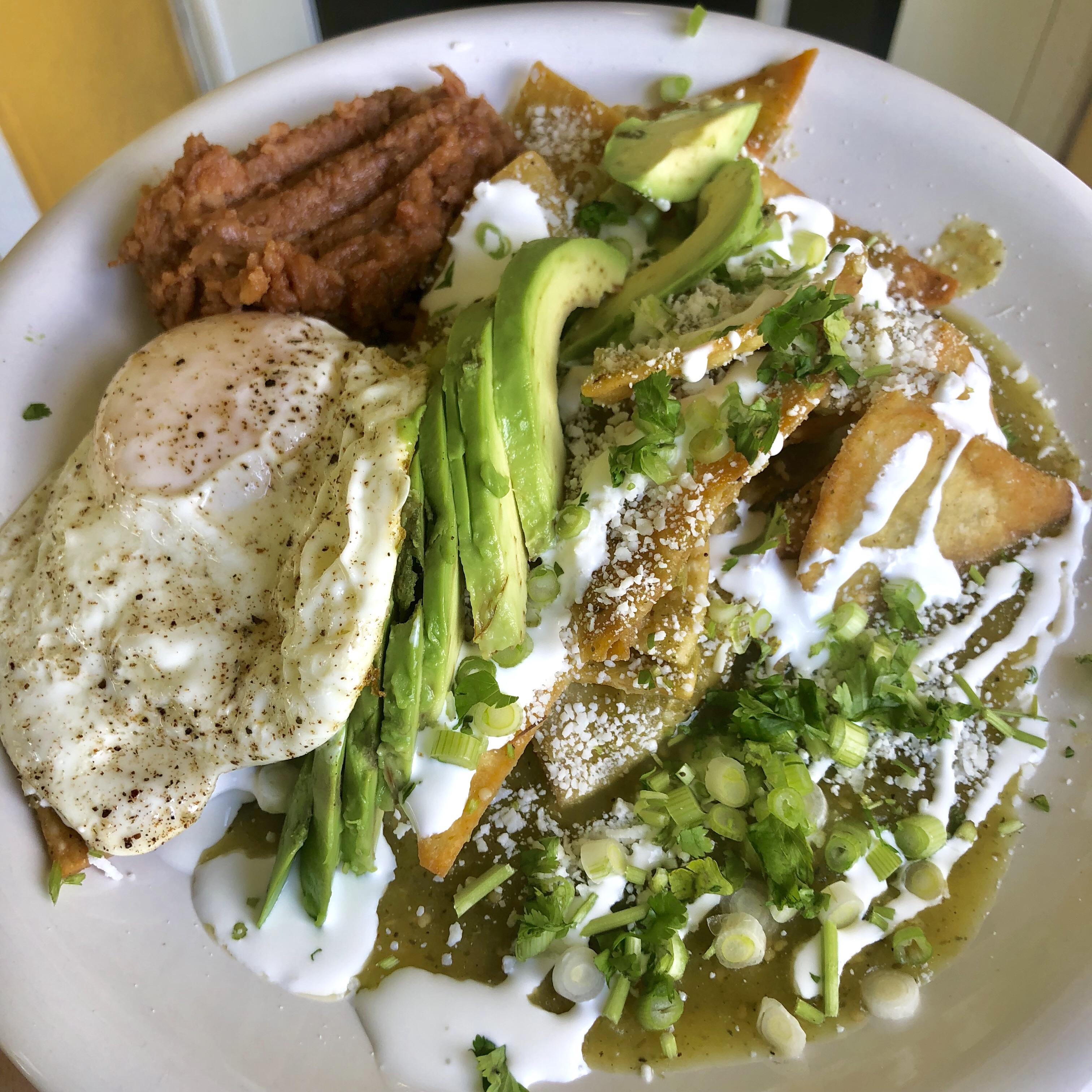 Green Chilaquiles, refried beans, overeasy egg, avocado, topped with