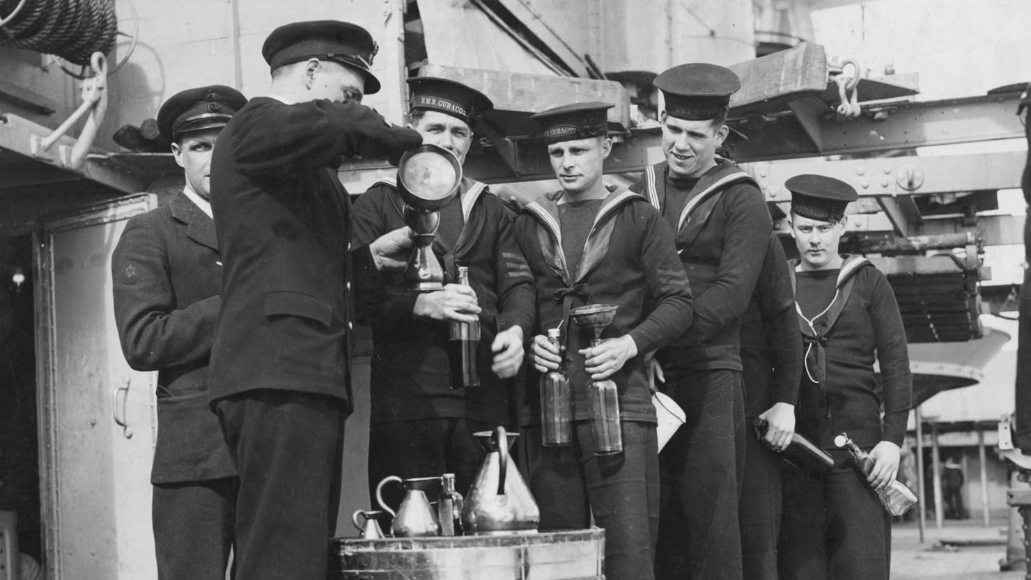 British sailors aboard HMS Curacoa line up to receive their rum ration