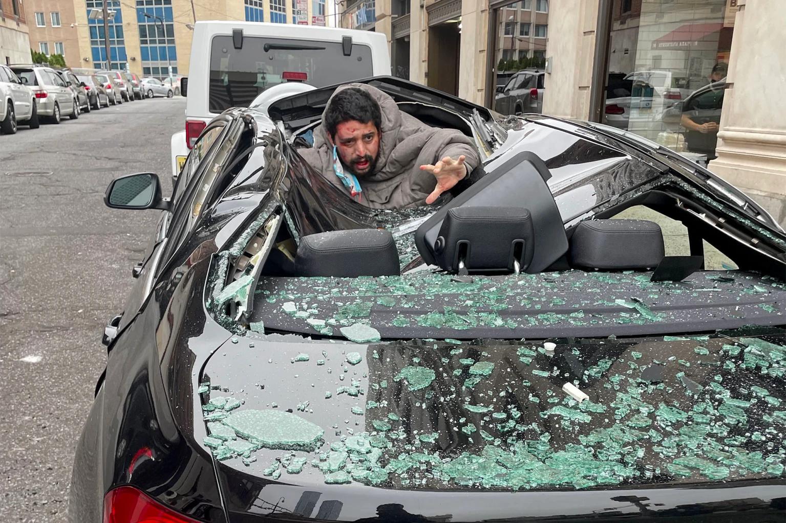 Guy crawling out of Beemer 330i that caught his fall from nine story