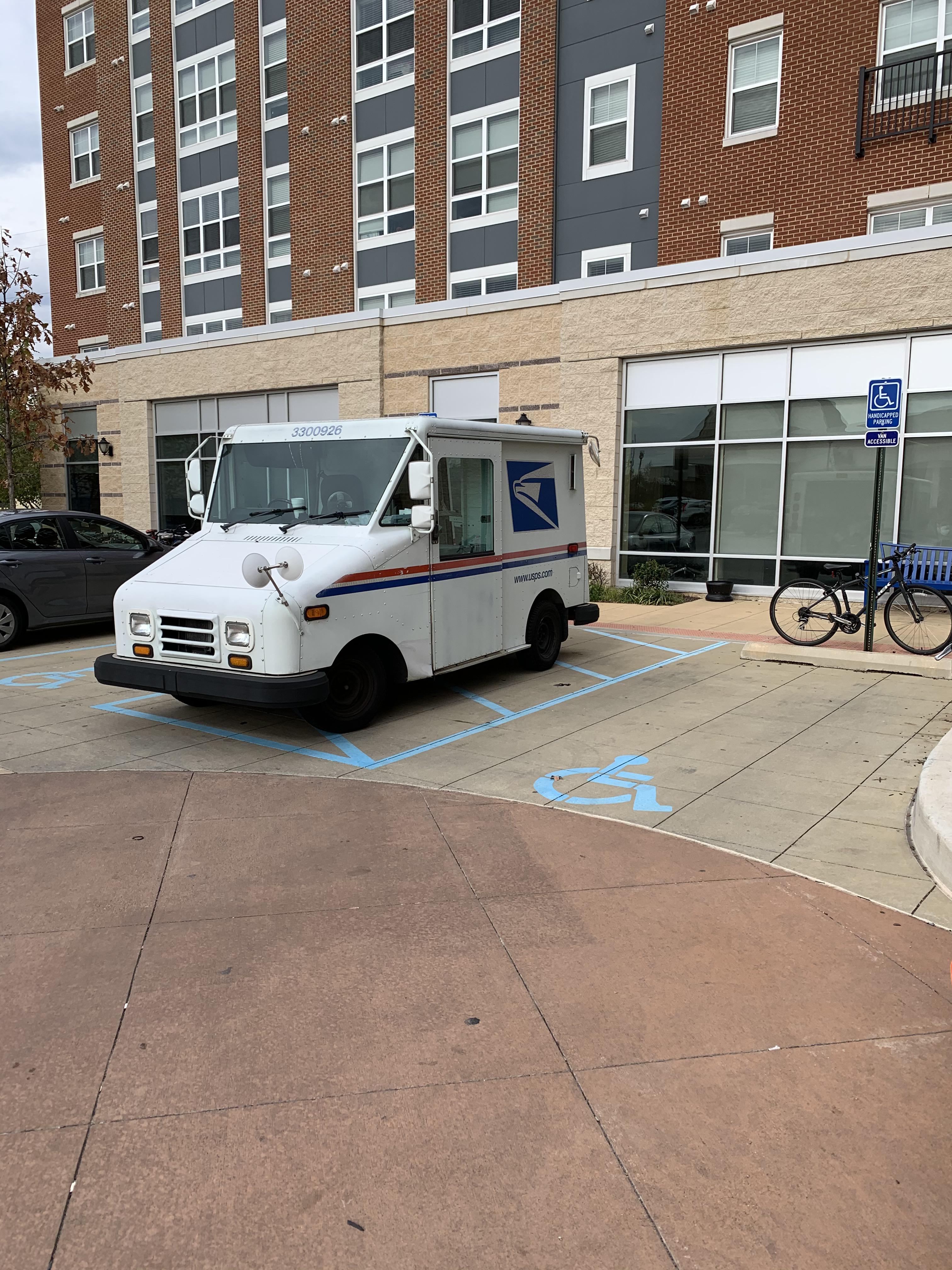 Somehow USPS found a way to park in 2 van accessible handicap spots at