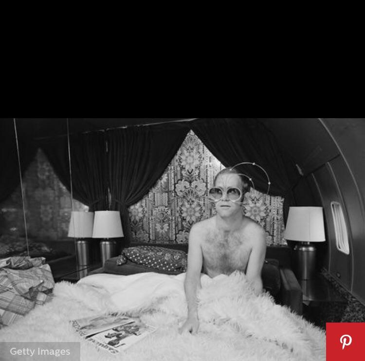 Elton John c.1976 in his luxurious bedroom in the sky (a plane ride has