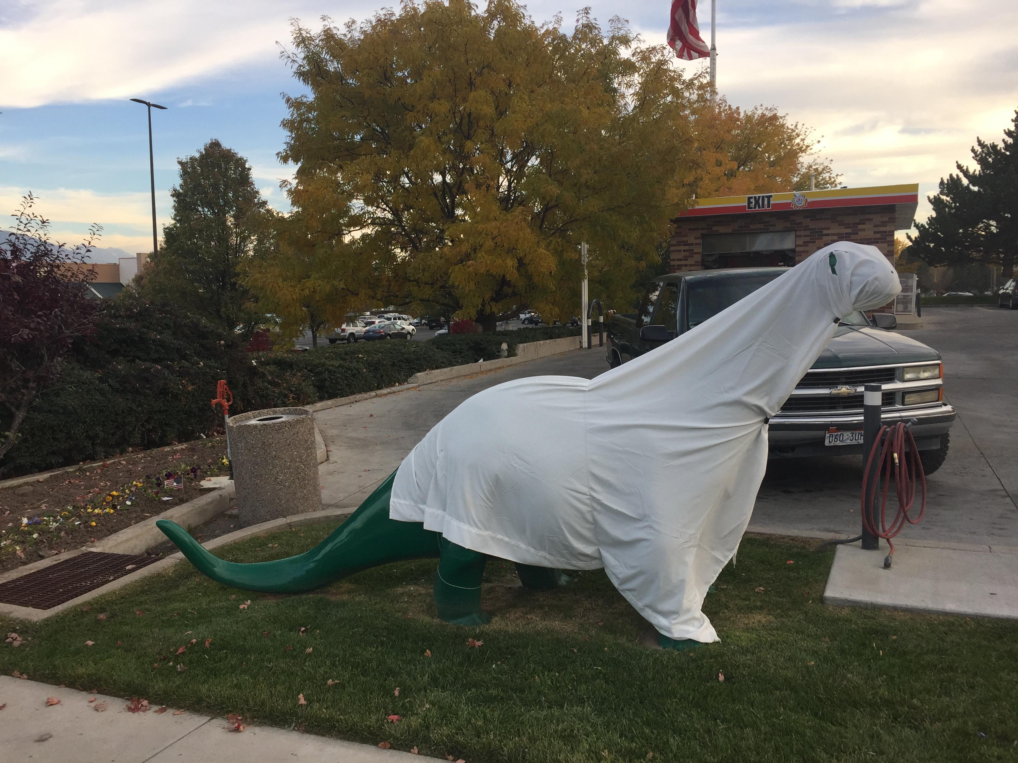 This gas station dinosaur dressed as a ghost for Halloween. r