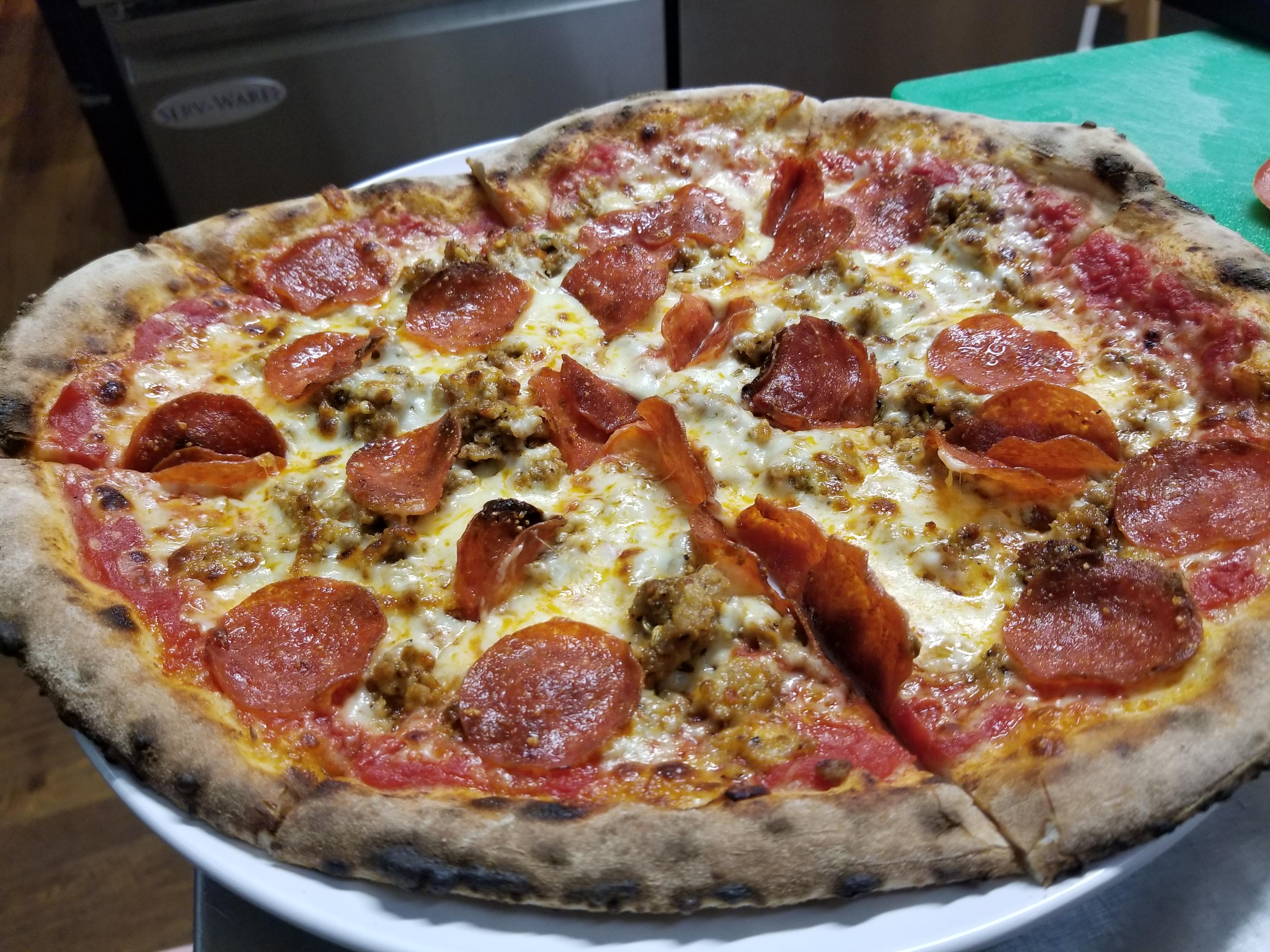 Spicy homemade crumbled sausage, pepperoni, and fontina cheese in a