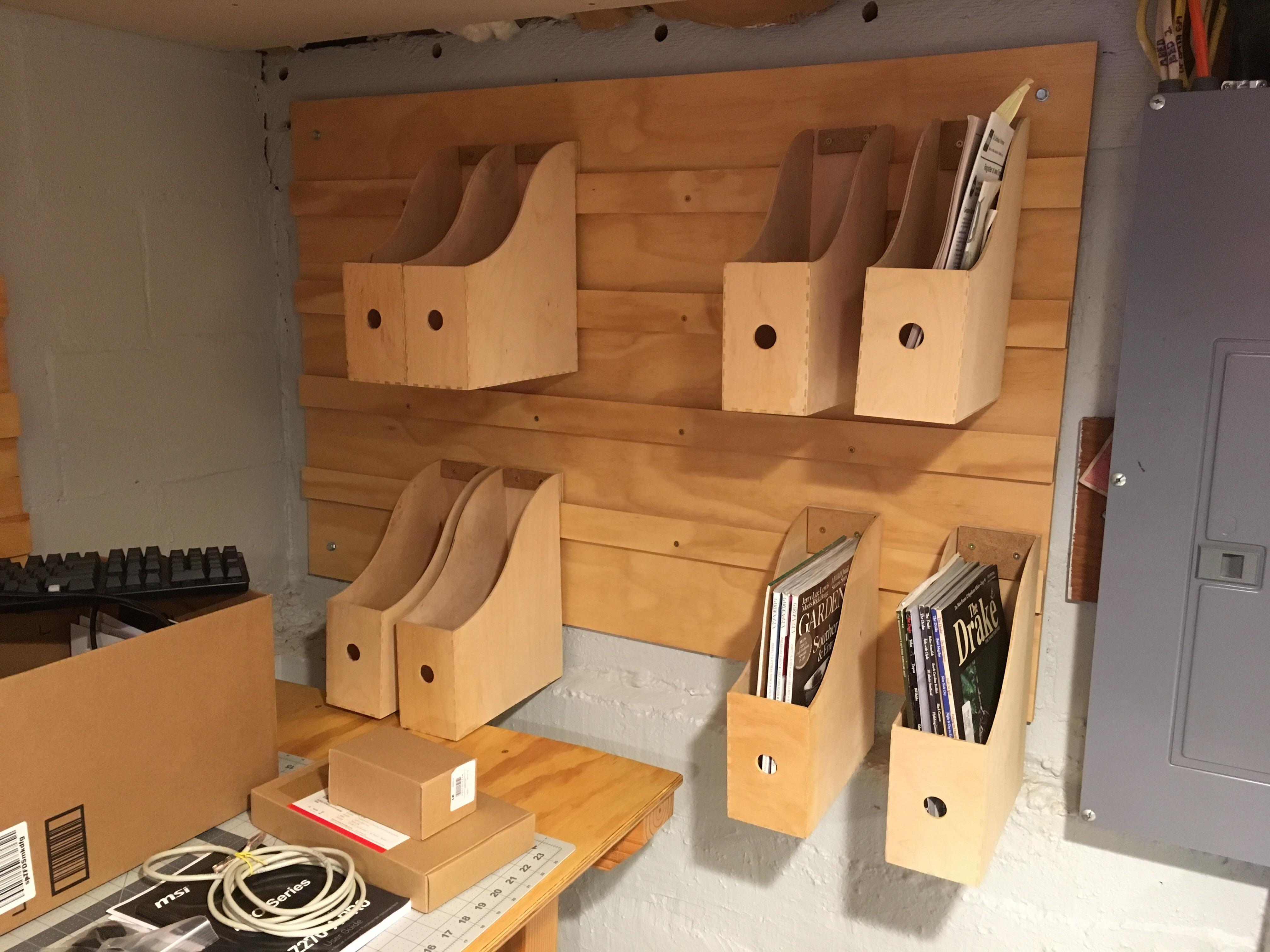 Repurposed IKEA magazine holders new wall for storing books, manuals