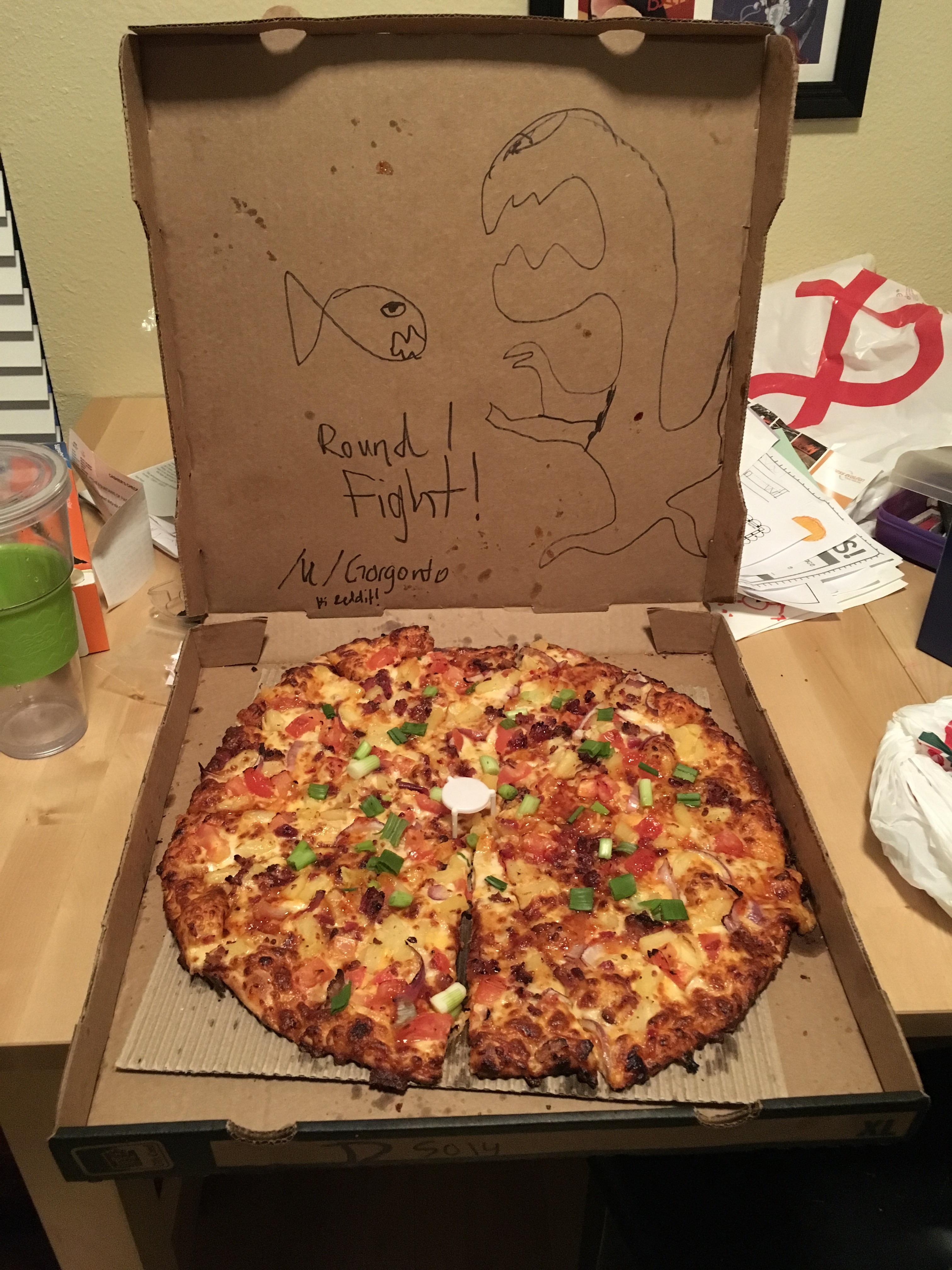 Local hero draws goldfish battling a TRex on pizza box; averts tragedy. r/DeliveryInstructions