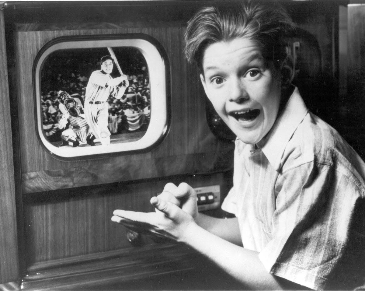 Boy watching a baseball game on a General Electric television receiver