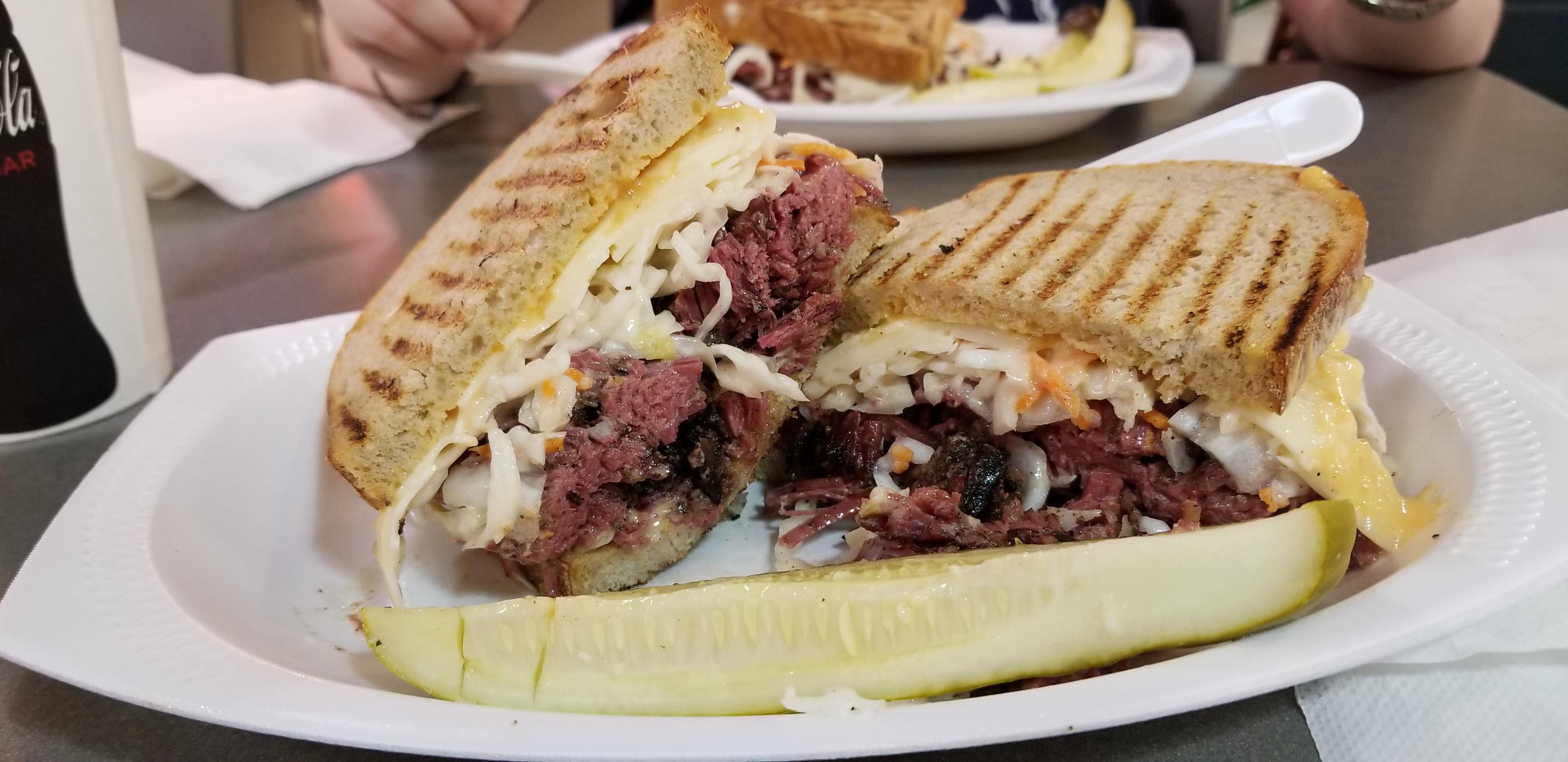 Pastrami on rye with slaw and mustard and side pickle from Hershel's