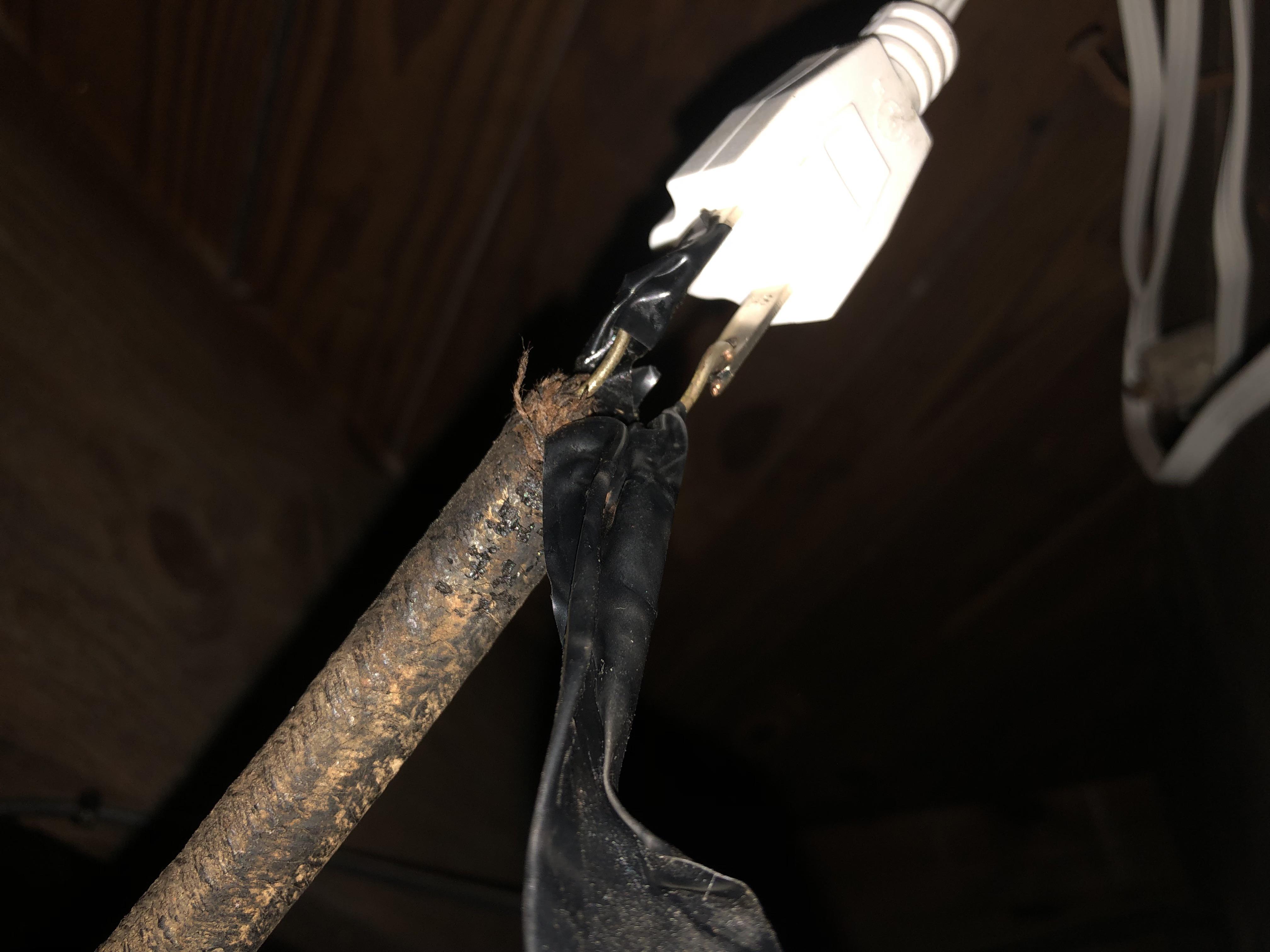 Under the electrical tape on a fluorescent light fixture cable… r