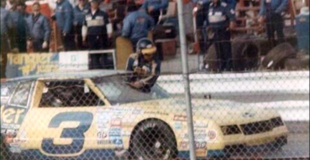 Dale Earnhardt cleaning mud off his windshield during a race at