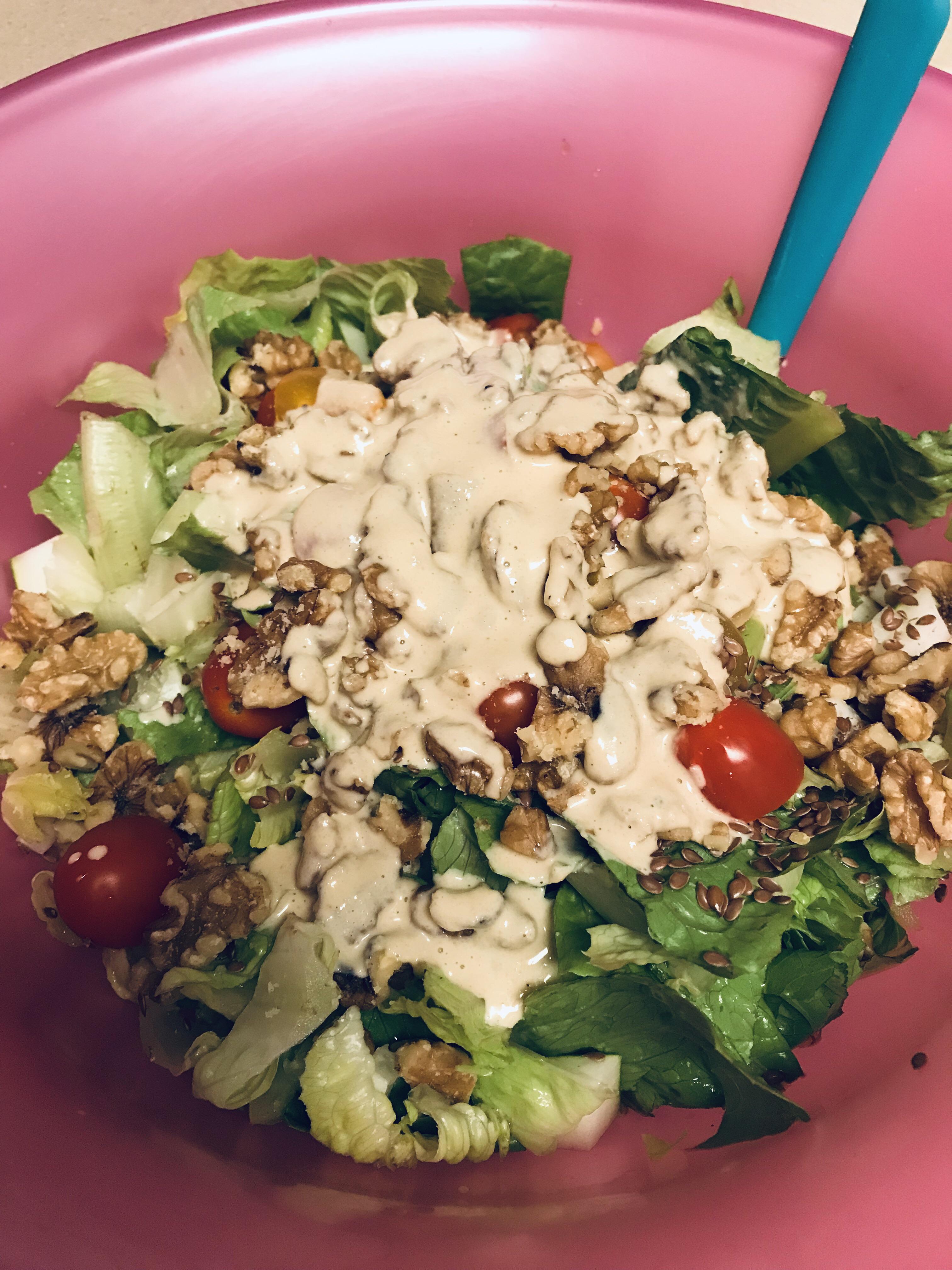 Salad with local tomatoes and cucumber, walnuts, flax seeds, and homemade lemon tahini dressing