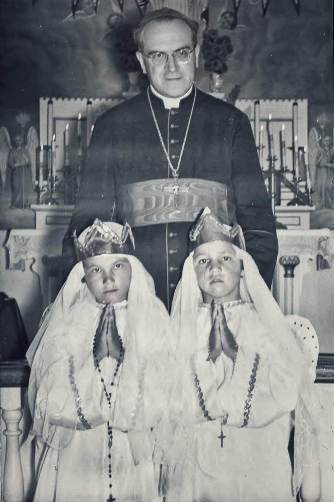 Roman Catholic priest stands over two praying Indigenous boys at Amos