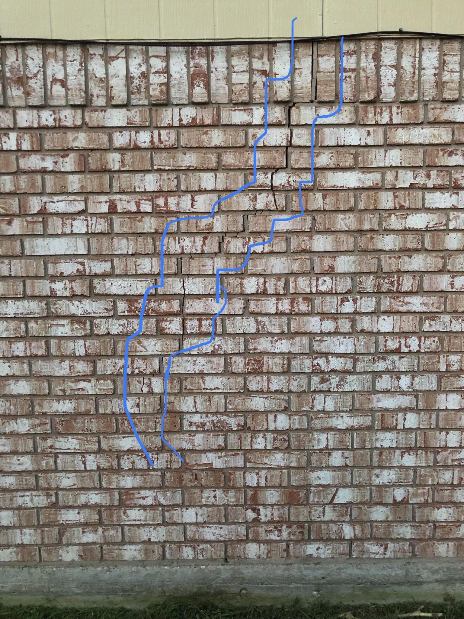 How to fix the outlined crack up the brick veneer on the side of my