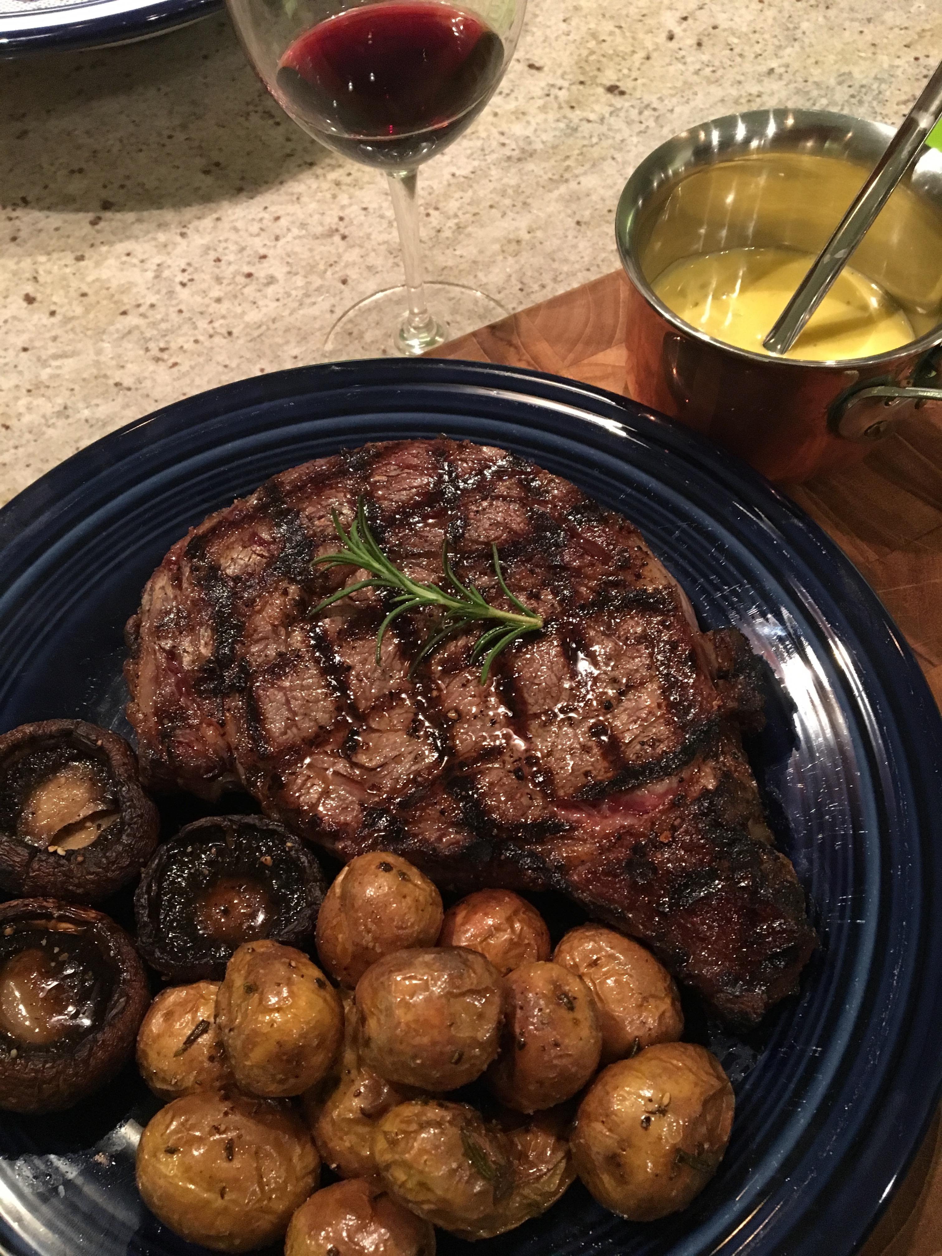 Ribeye steak with rosemary potatoes, mushrooms, and a side of bearnaise