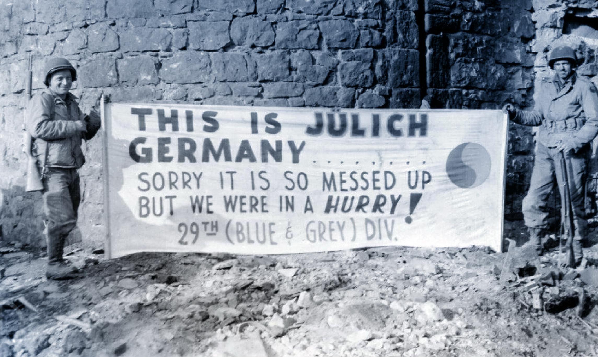 GIs of the 29th Infantry Div. ‘Blue & Gray’ at the entrance to Jülich