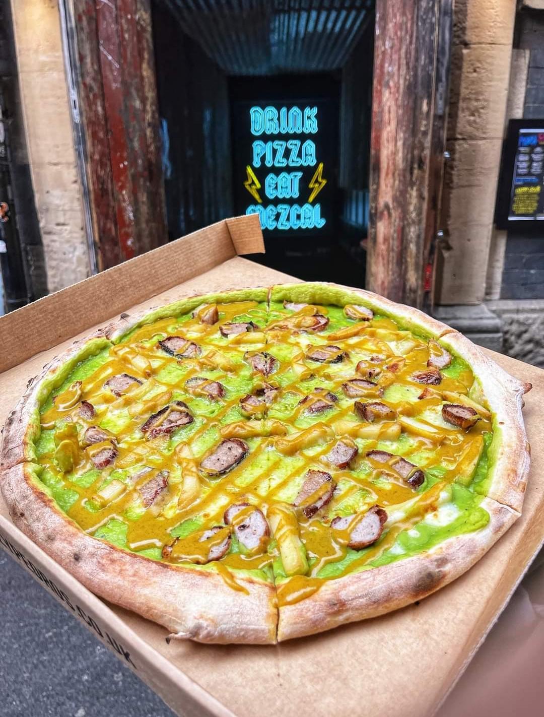 Chippy Pizza. Sausage and chips on a bed of mushy peas topped with