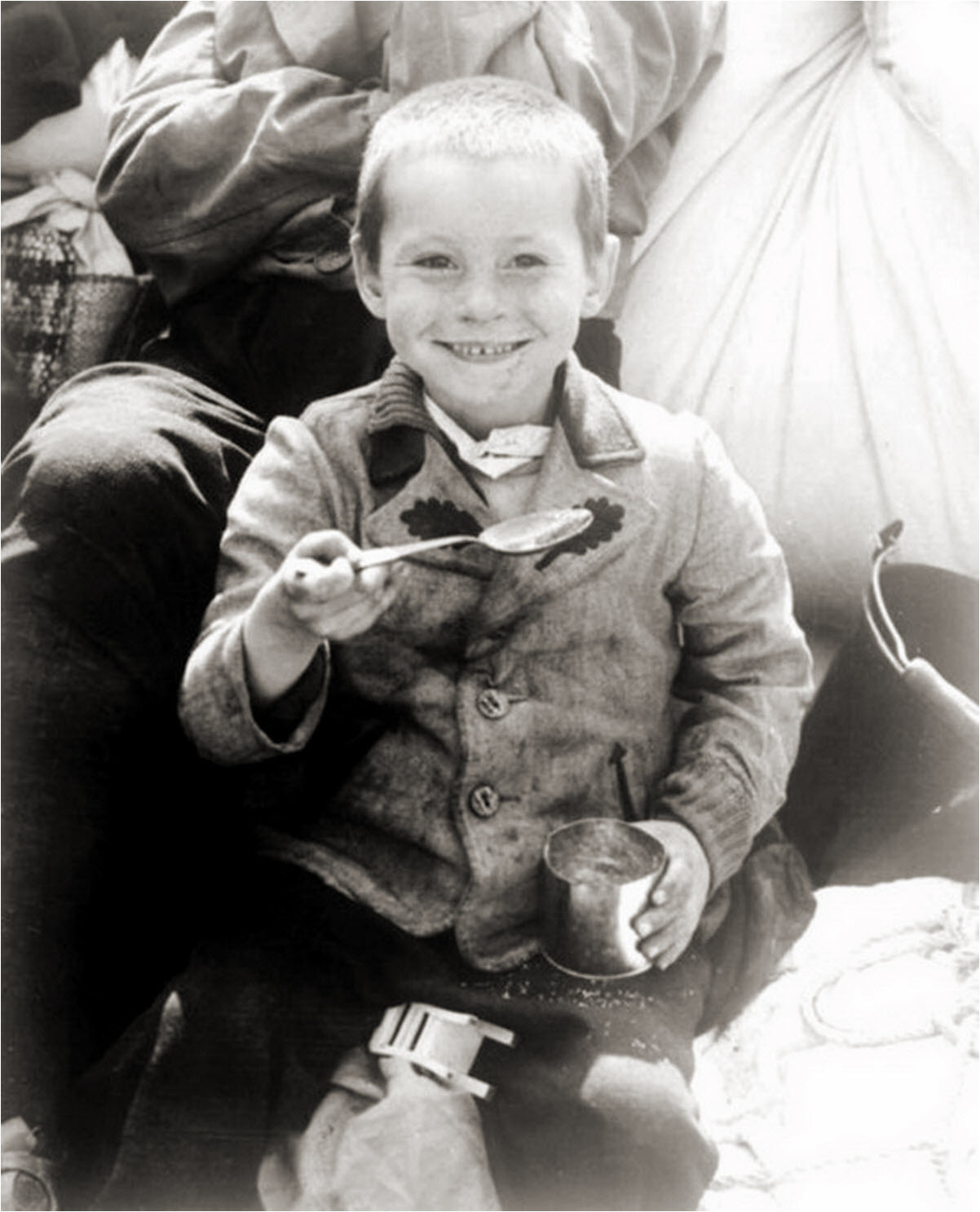 Polish boy rescued from a slave labor subcamp of Buchenwald enjoying US Army rations in 1945