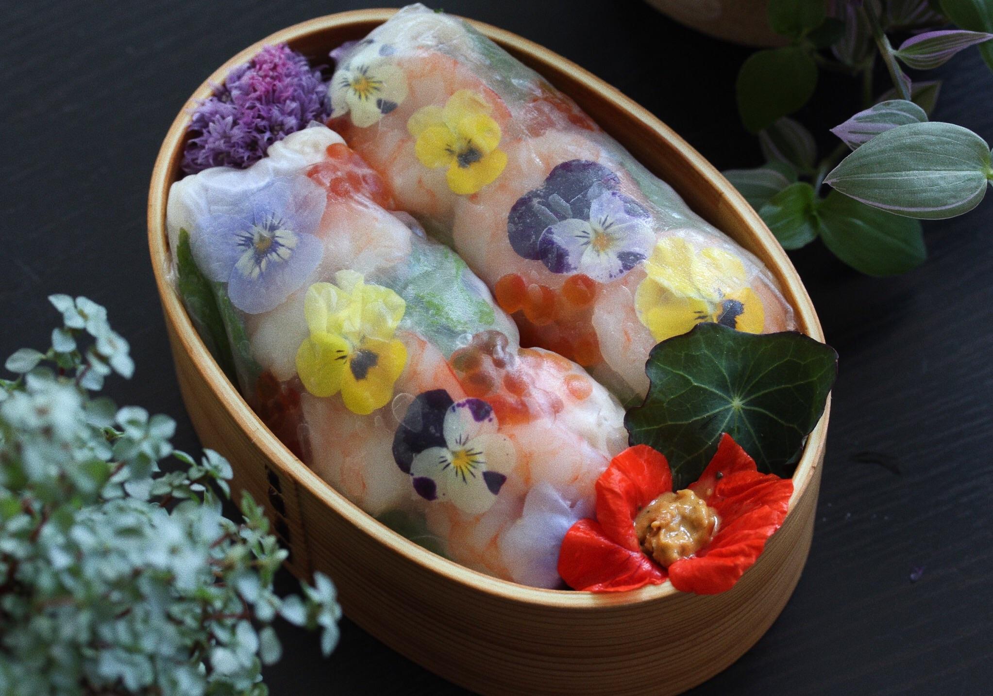 Fresh spring rolls. Nasturtium flower holding some peanut butter