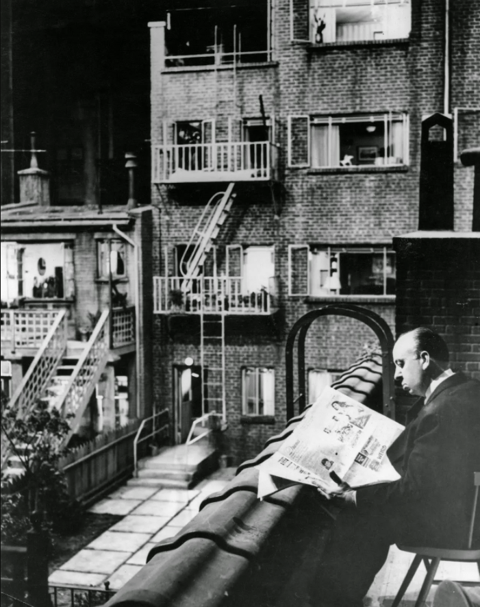 Alfred Hitchcock reading a newspaper on the incredible set of 'Rear