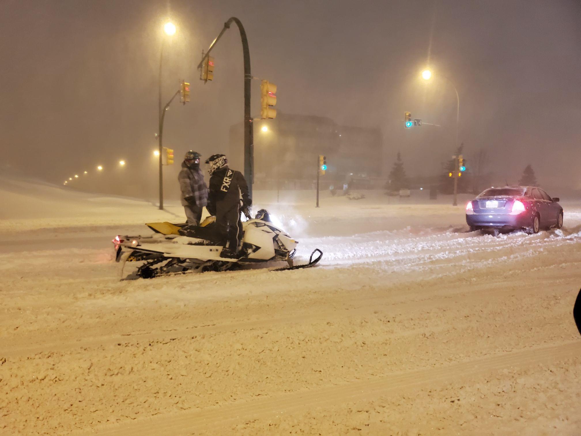 Snowmobilers helping cars get un stuck during a snow storm (Saskatchewan, Canada) r/pics