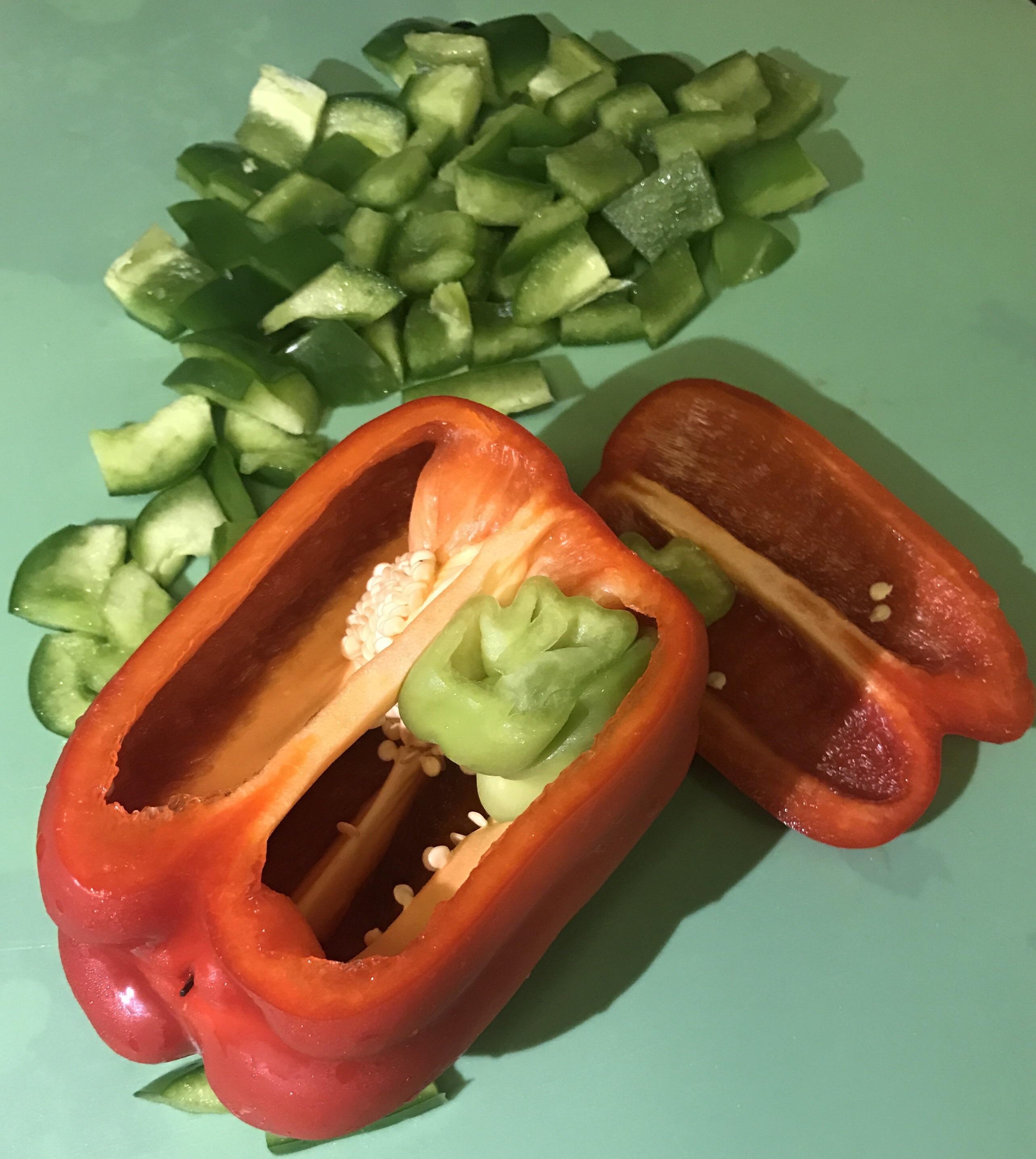 This red pepper with a baby green pepper growing inside it. r