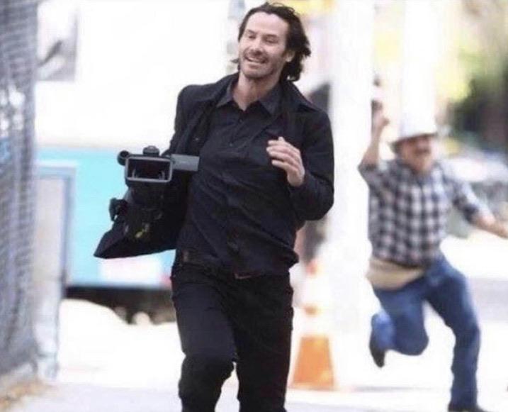 A Photo Of Keanu Reeves Running With A Camera He Took From From A