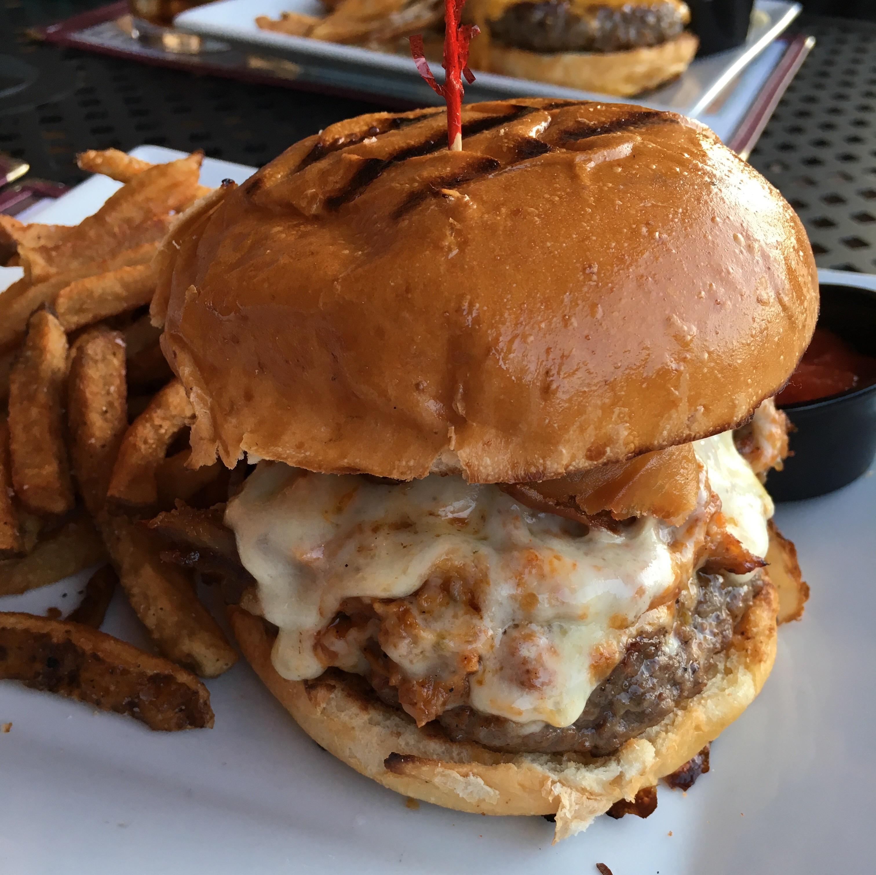 [I ate] Burger topped with pulled pork, bacon, pepper jack cheese