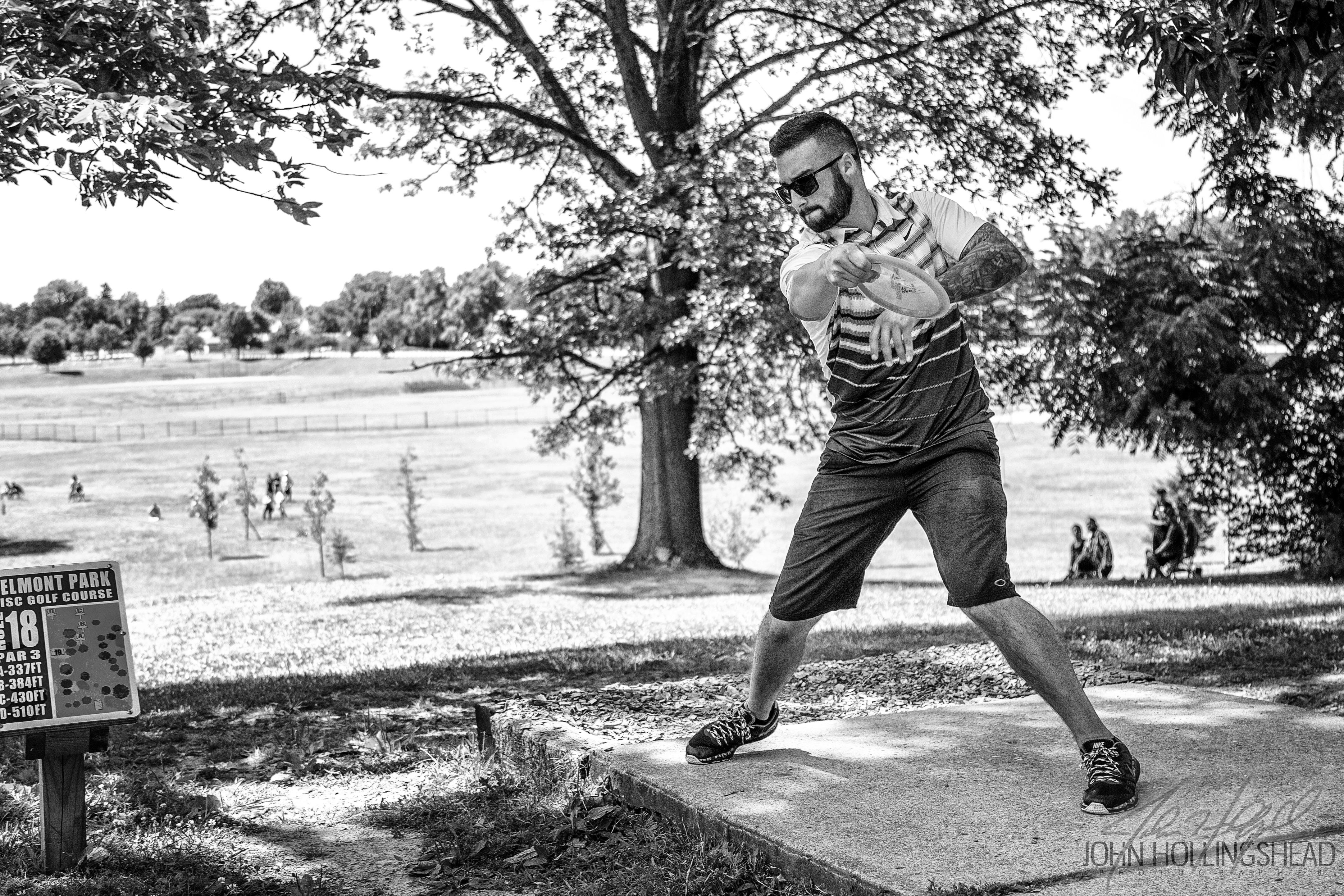 Drew Gibson throwing a drive on hole 18 at Belmont Park during the