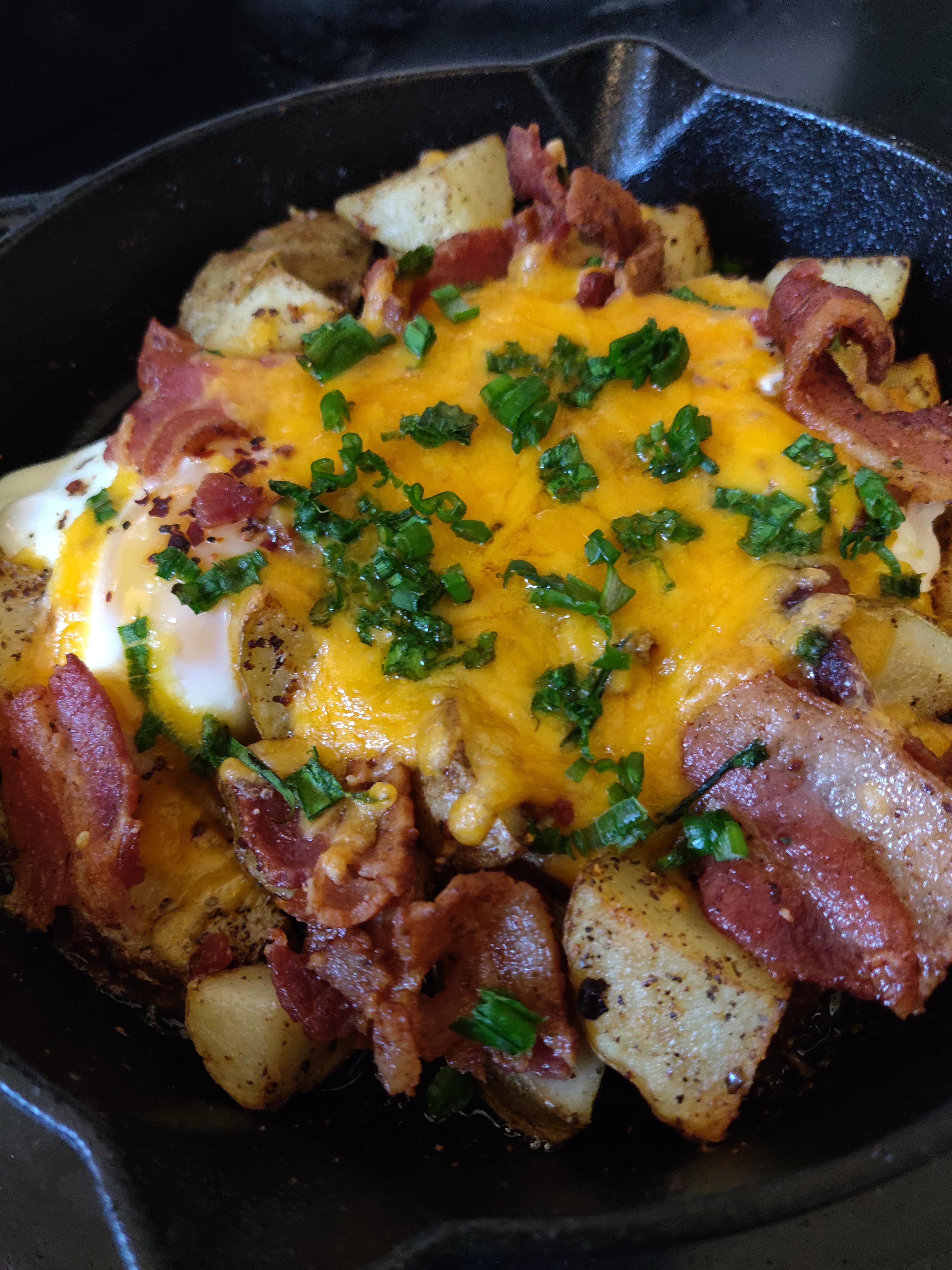 New to cooking with cast iron. Potatoes, bacon, eggs and cheddar. r
