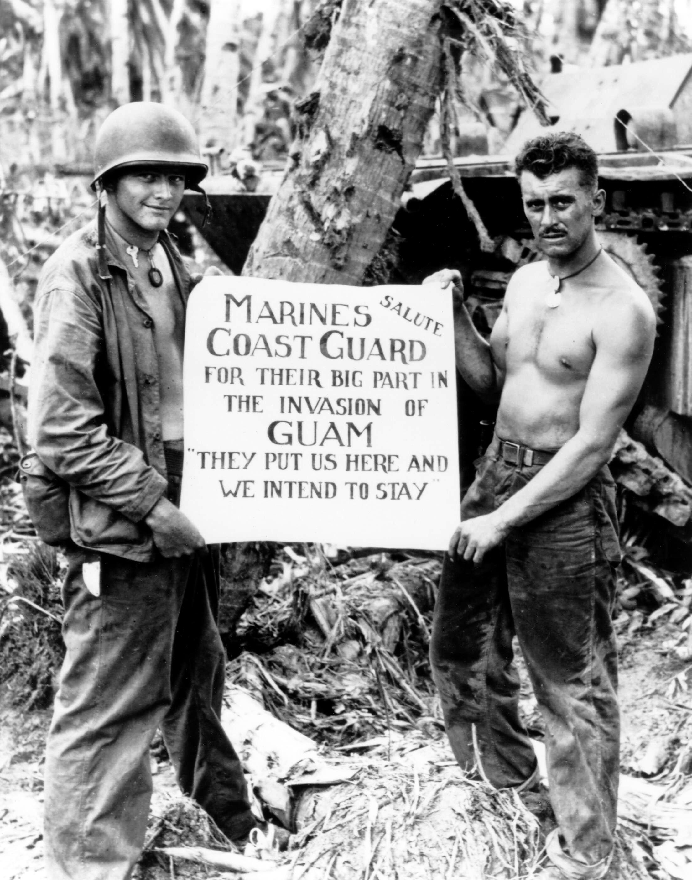 Two US Marines holding up a sign exhibiting importance towards the