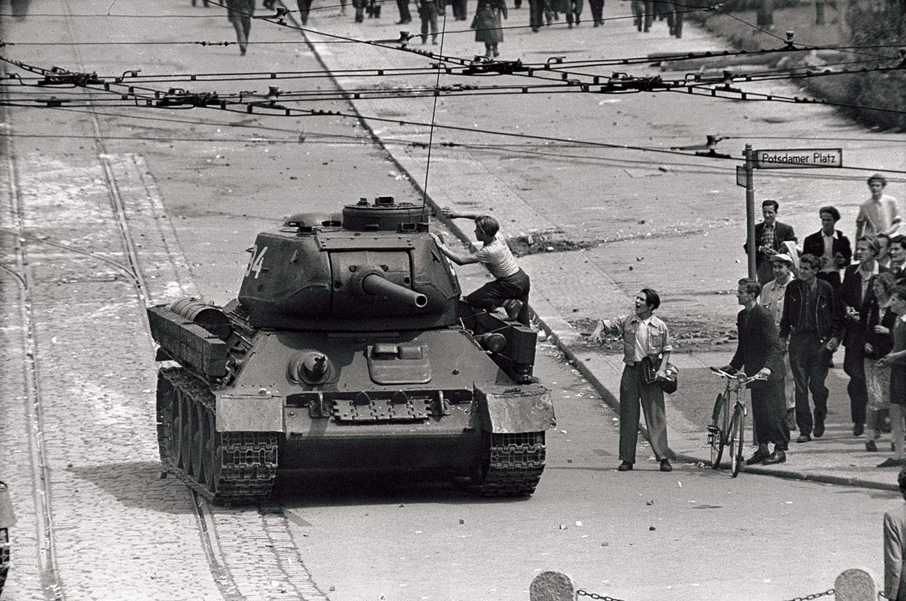 East German demonstrator climbs a T34/85 tank of the Group of Soviet