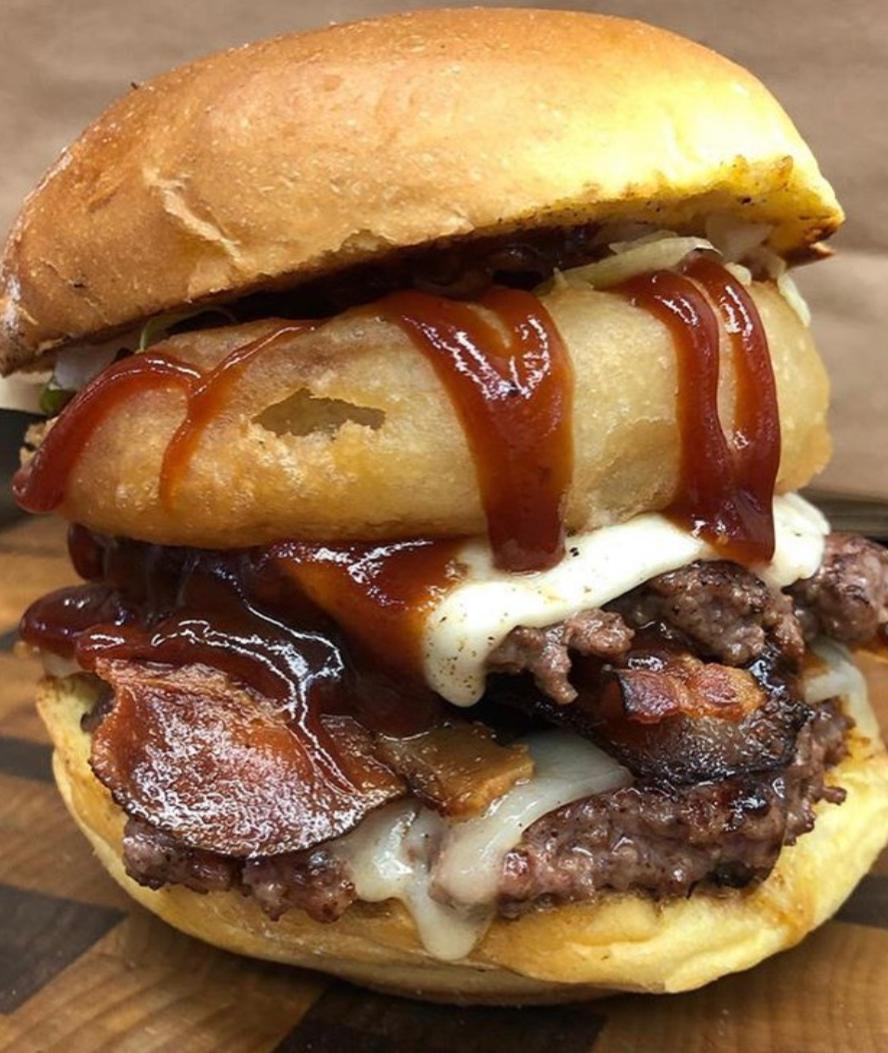Double Petty Big Tex Beef Burger with BBQ Sauce Cheddar and Onion Rings