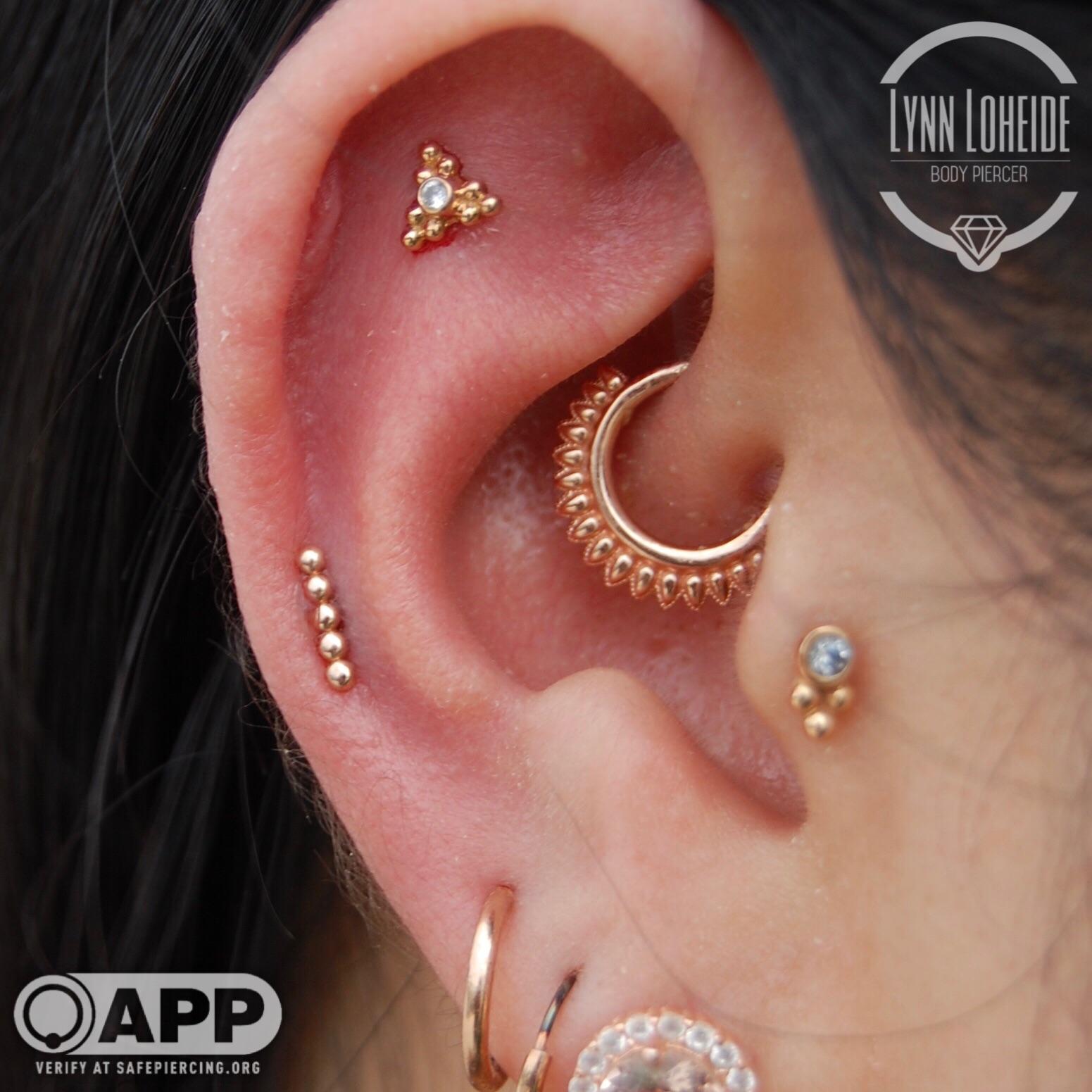 Healed tragus, healing daith, and fresh flat and helix by Lynn at Amato