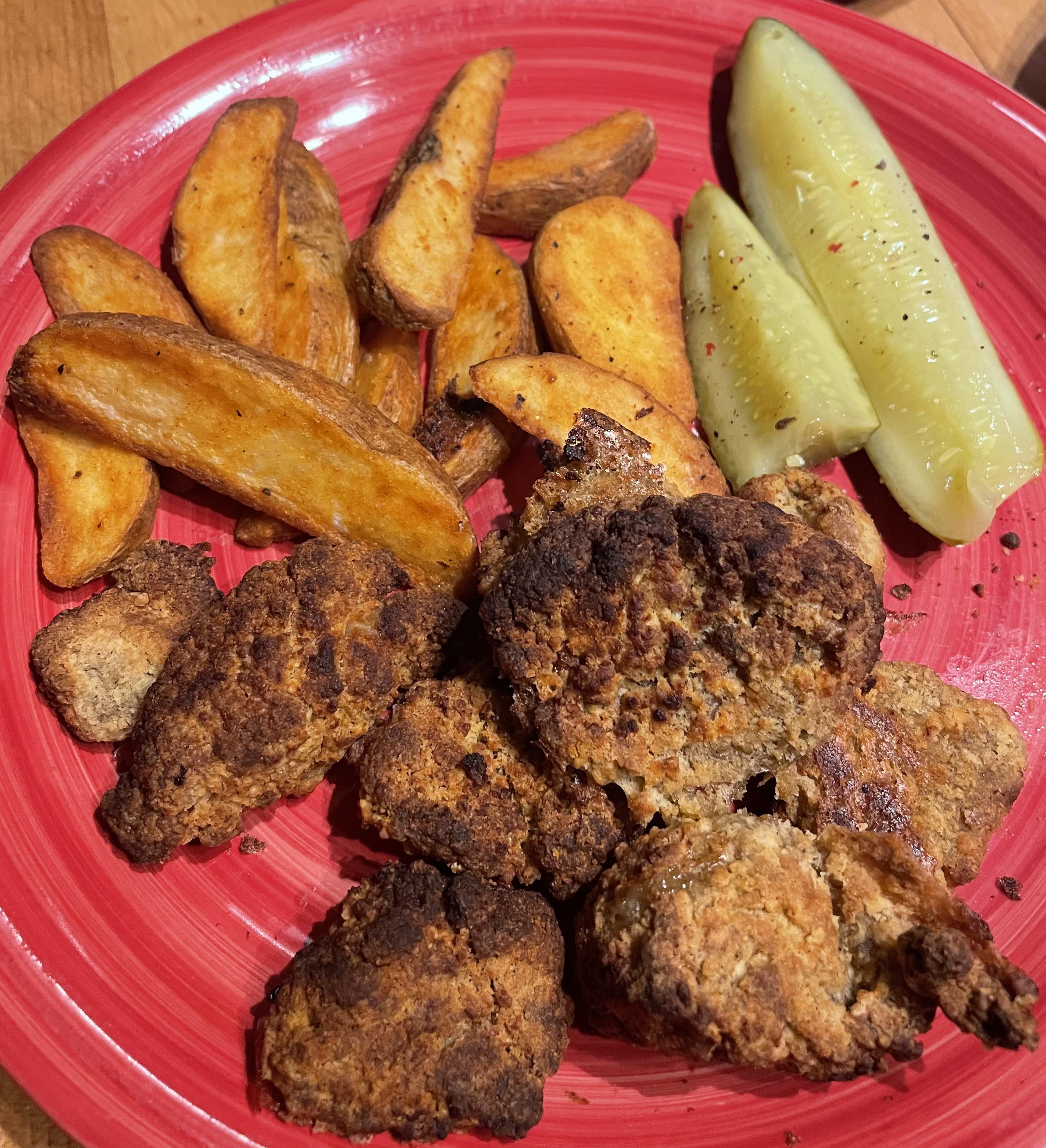 Air fried chicken nuggets and potato wedges with dill pickles and ranch