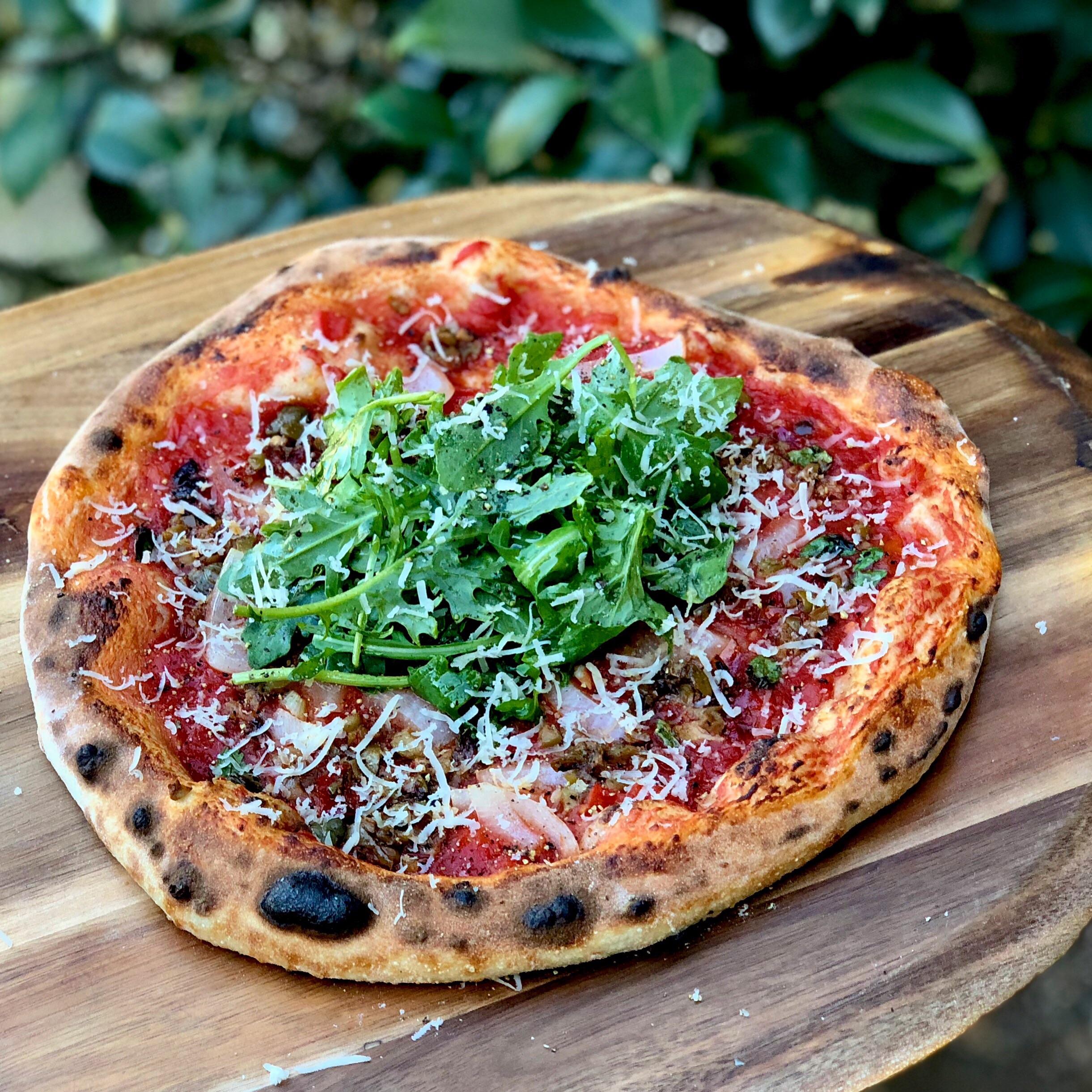 Wood fired pizza red sauce, pickled onions, olive tapenade, oregano