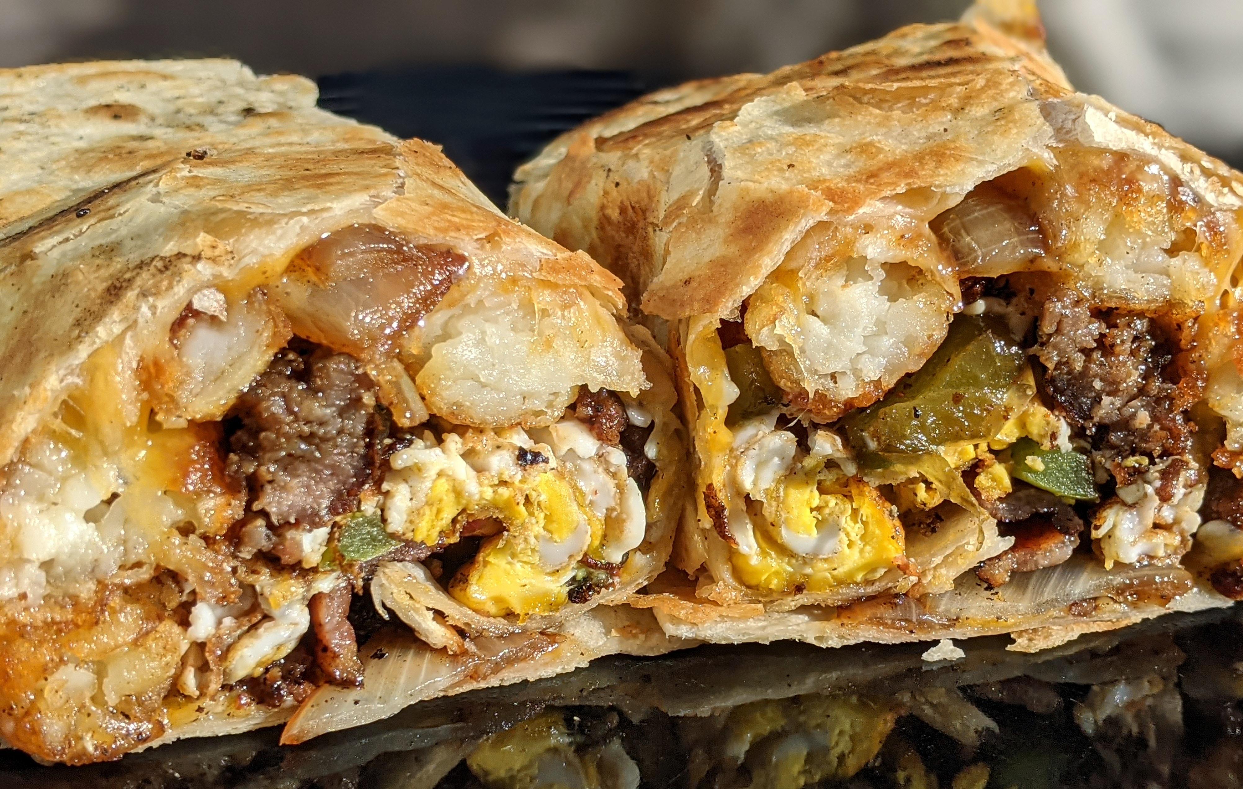 Breakfast burrito loaded with sausage, eggs, peppers, onions, bacon