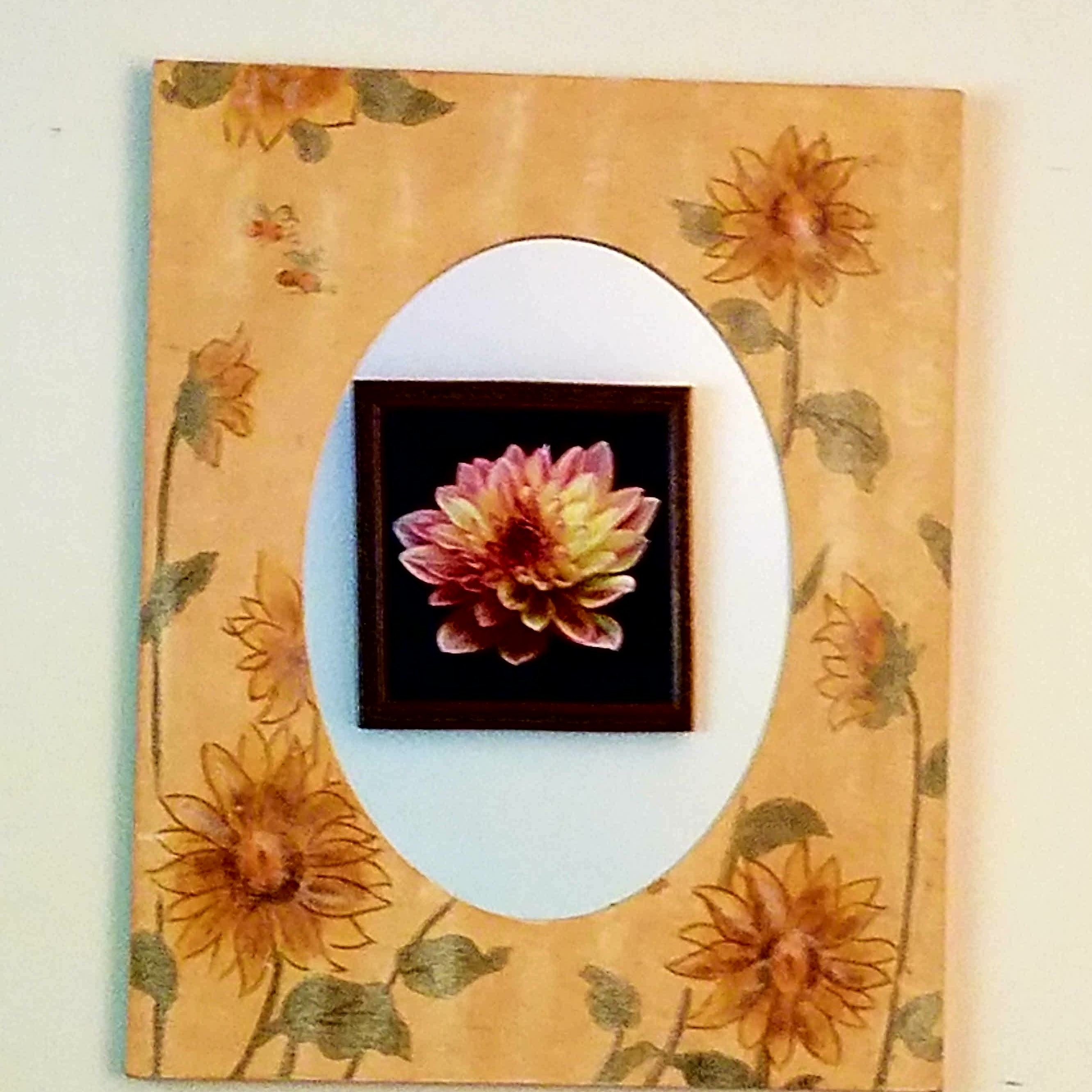 Flower mirror frame with a painting of a flower in the reflection. r