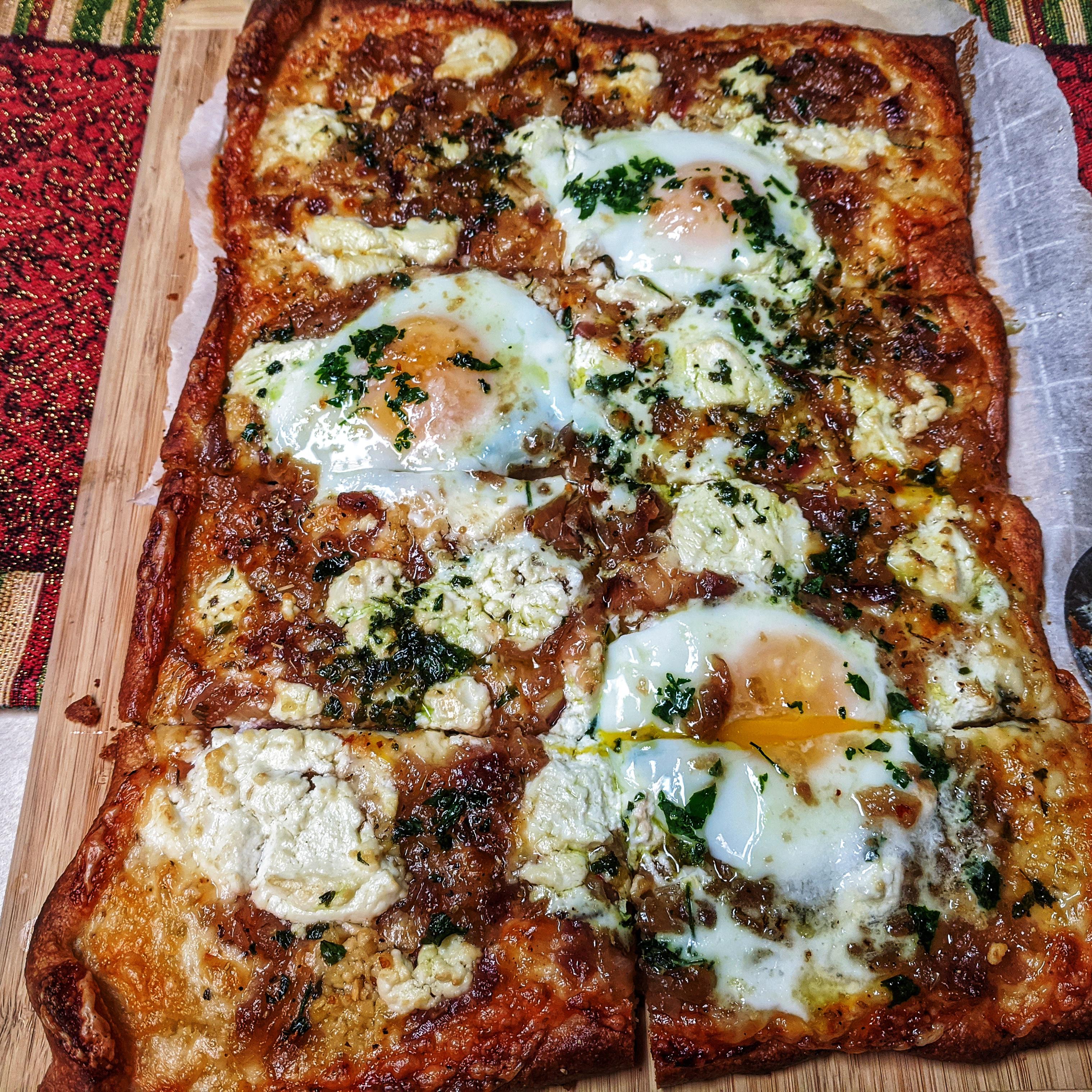 Breakfast pizza with caramelized onions, goat cheese and eggs. r
